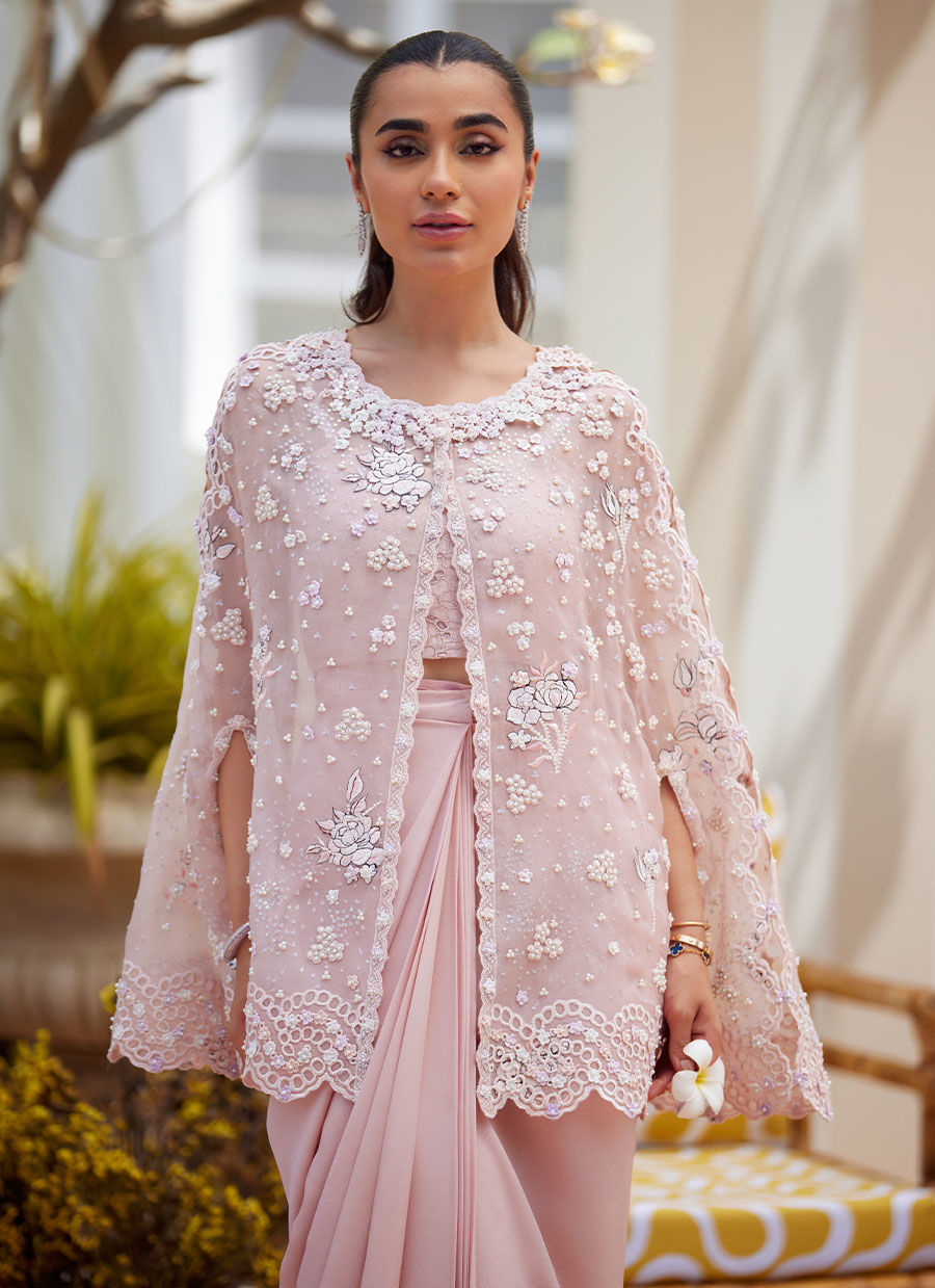 Effortless grace meets artistic craftsmanship in this straight long shirt ensemble. Delicately scattered across the fabric, floral motifs are rendered in intricate embroidery designed to mimic the softness and nuance of pencil colour shading. These artistic blooms are further elevated with delicate silver hand-work and subtle self-colored sequins, creating a harmonious blend of texture and light. The neckline and collar are trimmed with a scalloped border, hand-embellished with classic mukesh work, adding a