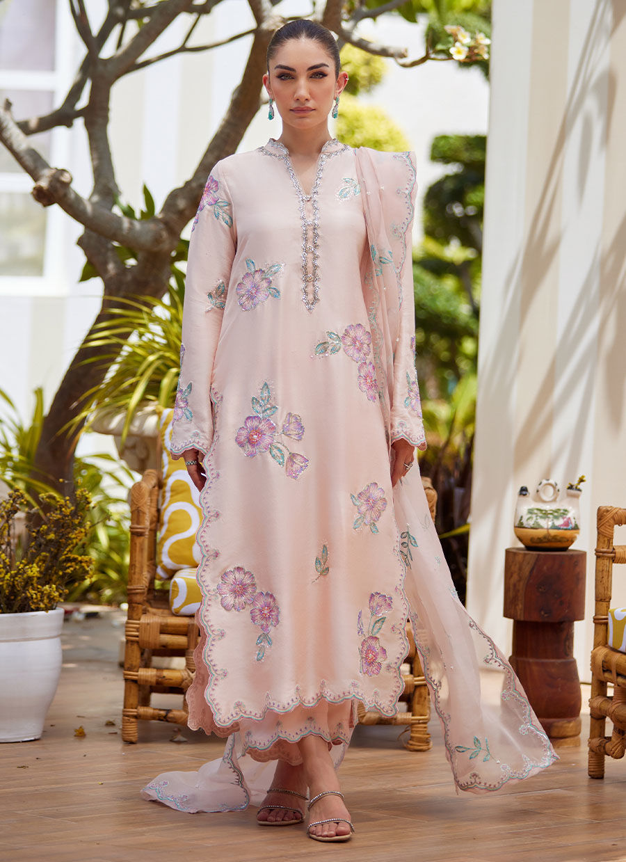 Model wearing blush pink floral embroidered dress from Farah Talib Aziz, ideal Pakistani luxury pret for summer garden parties in the UK.
