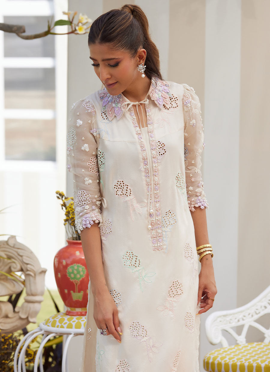Model wearing ivory embroidered dress with pastel floral details from Farah Talib Aziz, perfect for Pakistani luxury pret in the UK.