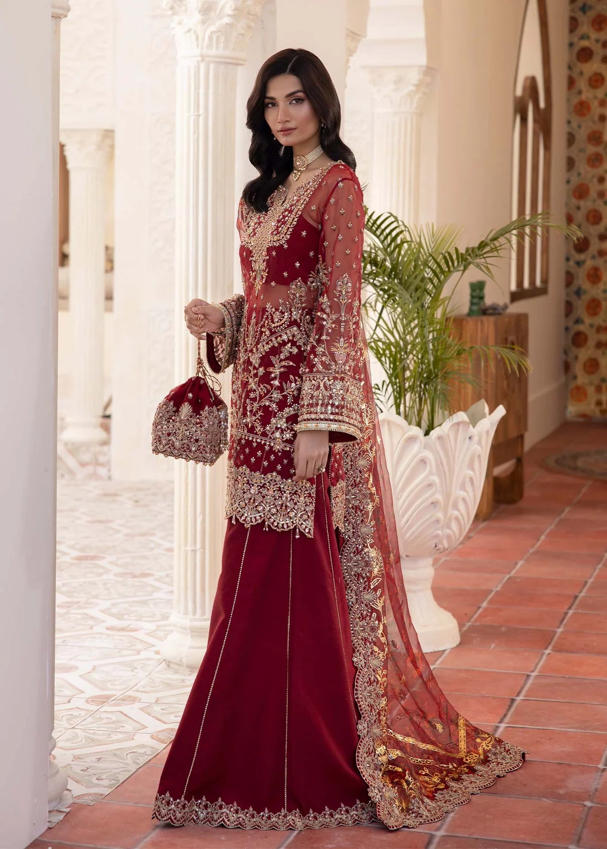 Model wearing deep red Zehrah outfit from Kanwal Malik with gold embroidery—Pakistani luxury pret perfect for weddings, shop in UK online.