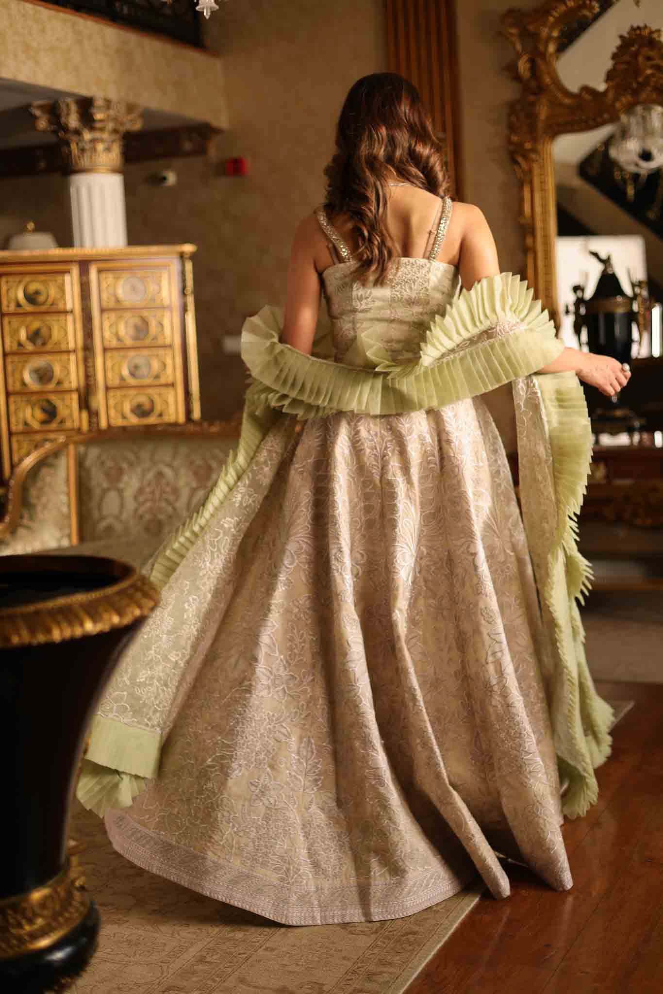 Model wearing beige and pastel green floor-length flared dress with ruffle accents from Mysie By Tahira's Esmera, Pakistani clothes online in UK.