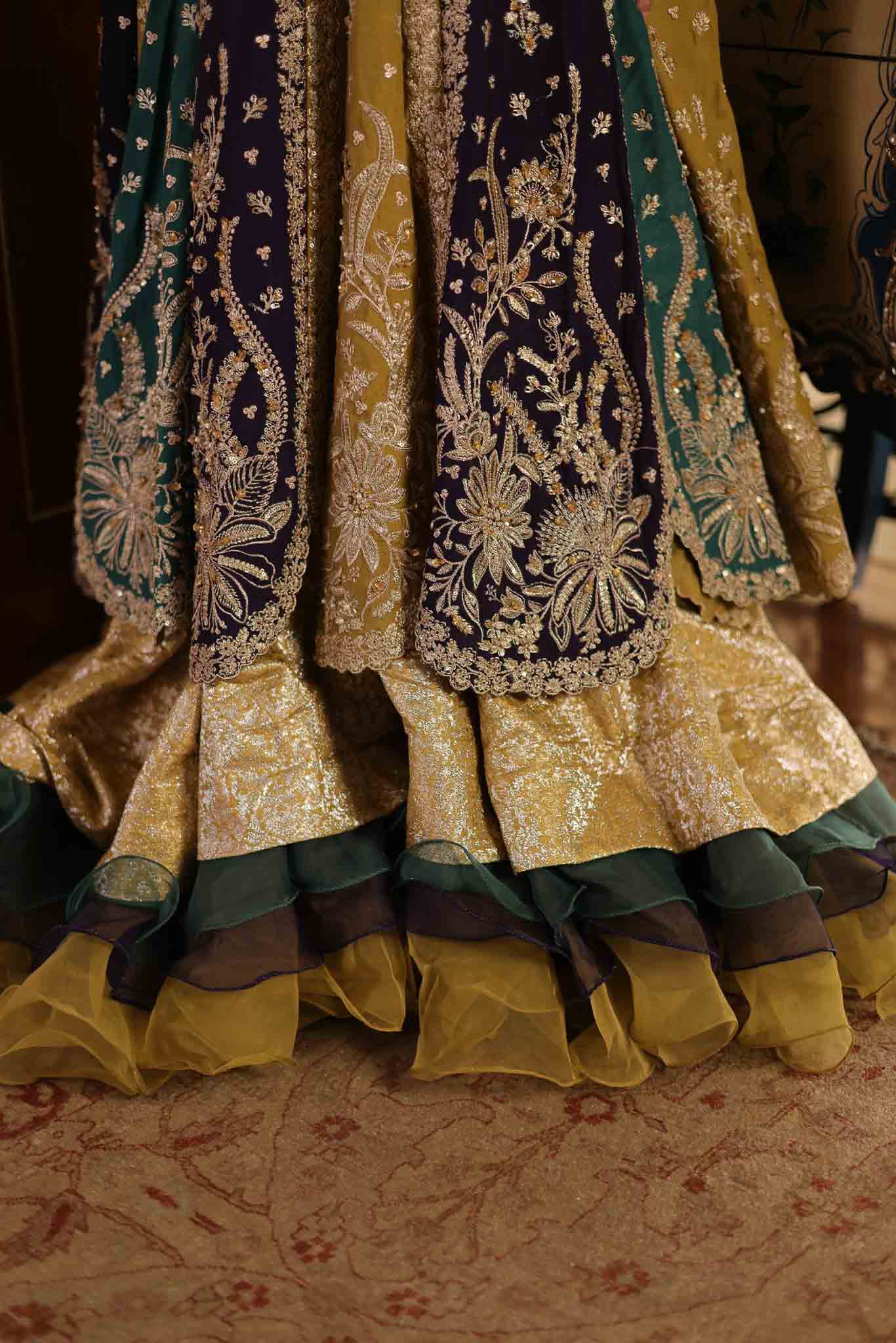 Model wearing multicolor panelled pishwas with mustard frill lehenga from Mysie By Tahira's Nazneen, Pakistani Luxury pret in UK.