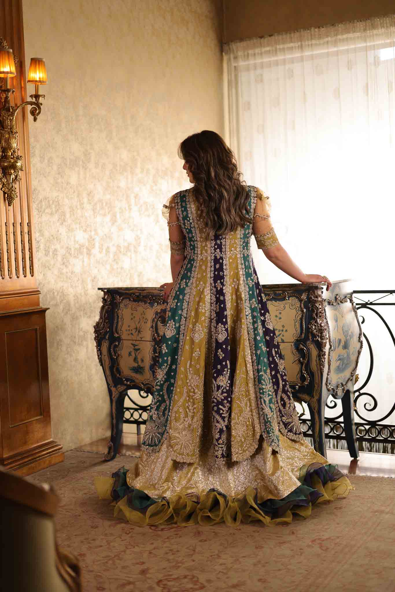 Model wearing multicolor panelled pishwas with mustard frill lehenga from Mysie By Tahira's Nazneen, Pakistani Luxury pret in UK.