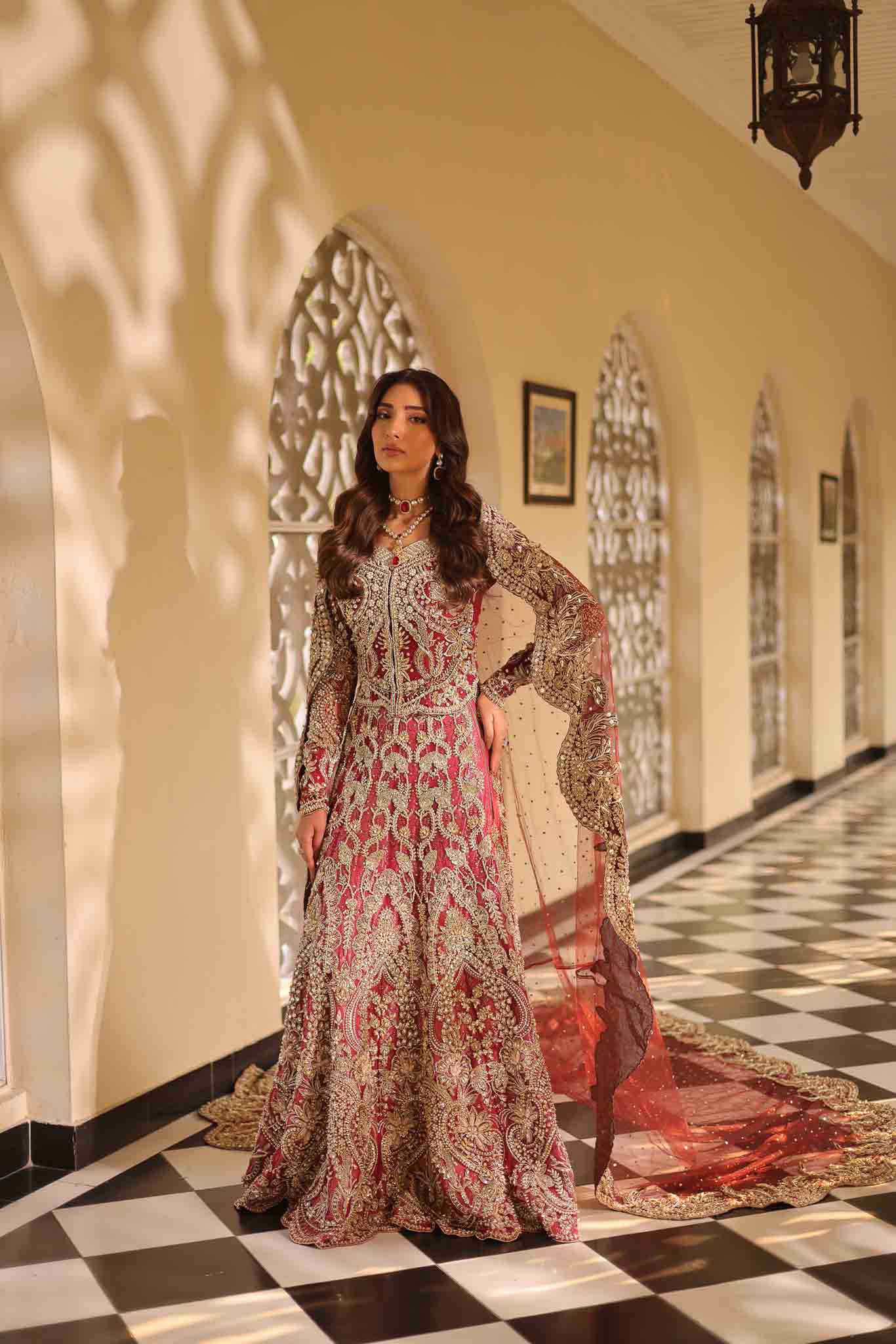 Model wearing deep red and gold bridal gown AURAA from Mysie by Tahira, Pakistani luxury pret available online in UK for weddings.