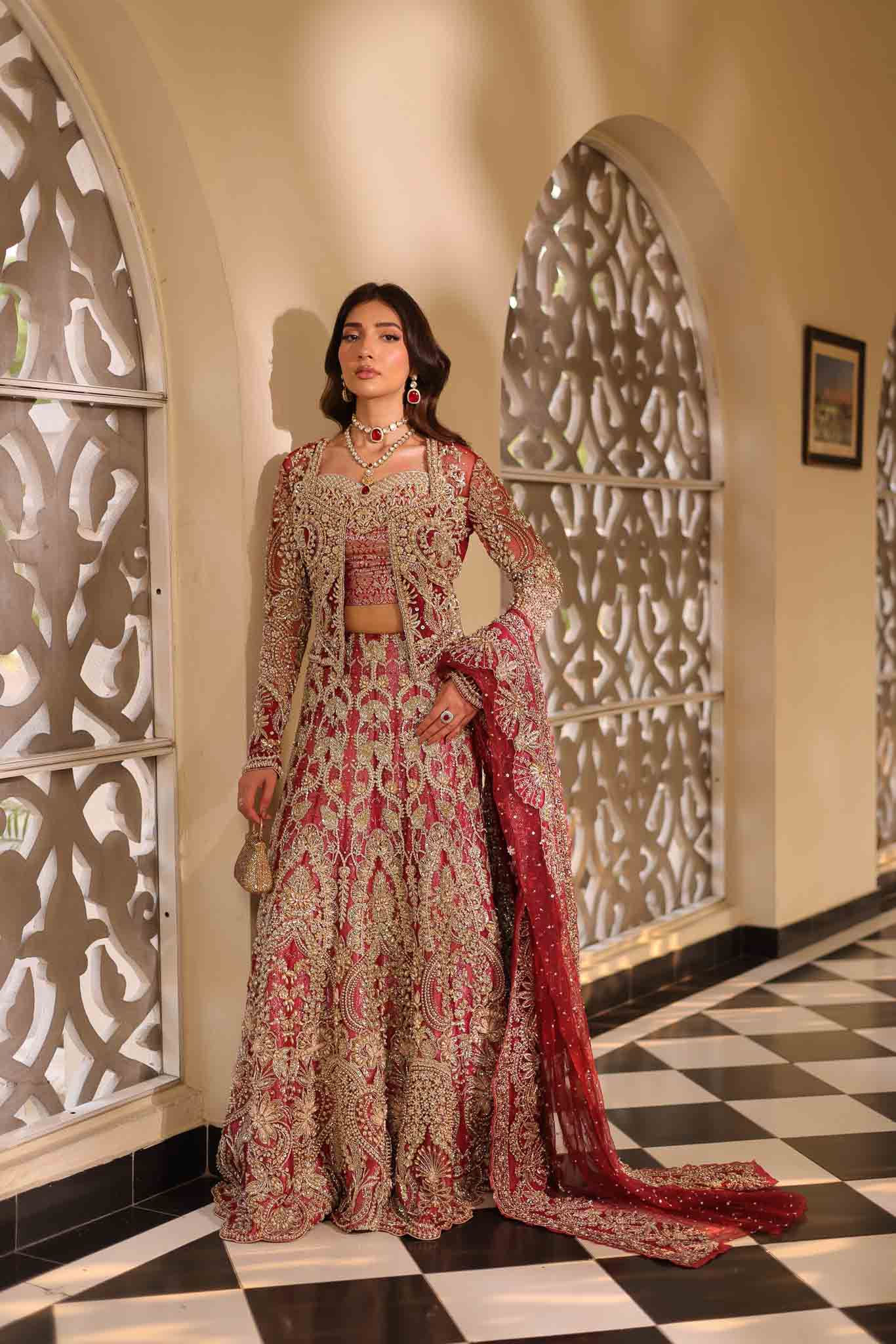 Model wearing deep red and gold bridal gown AURAA from Mysie by Tahira, Pakistani luxury pret available online in UK for weddings.
