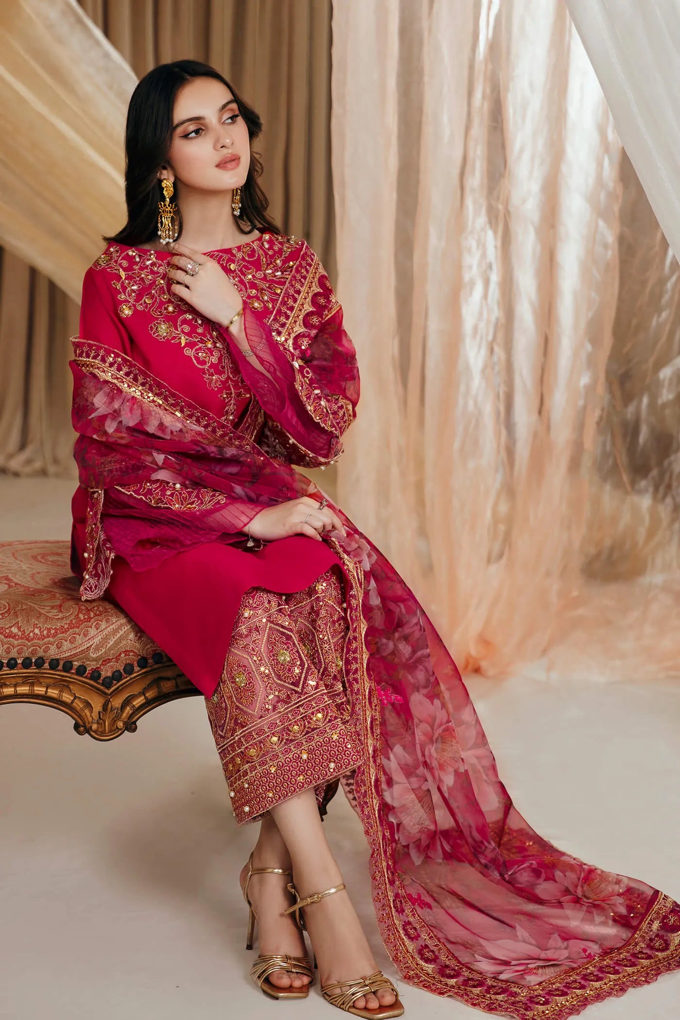 Model wearing Faiza Saqlain's Radiant Bloom dress from the Musferah Saad Mystere Eid Collection '24. A striking magenta Pakistani Eid dress with detailed gold embroidery and a floral dupatta, perfect for those seeking Pakistani designer clothes in the UK.