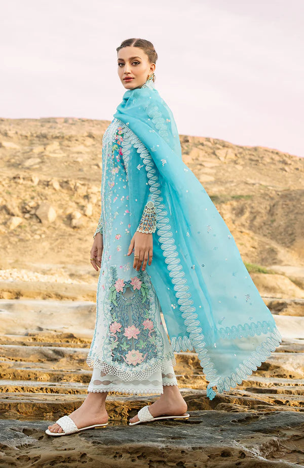Model wearing aqua blue embroidered dress with white trousers and printed dupatta from Soraya Noa Summer Casual Pret 2025 Serenade. Pakistani luxury pret UK.