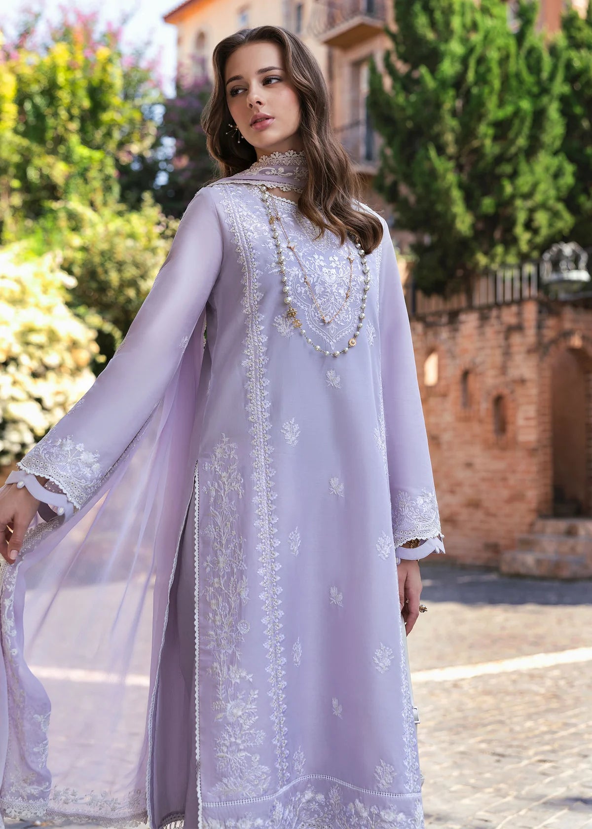 Model wearing Kanwal Malik Siena KM Basics '25 Zoe in soft lilac with delicate embroidery. Shop Pakistani luxury pret online in the UK.