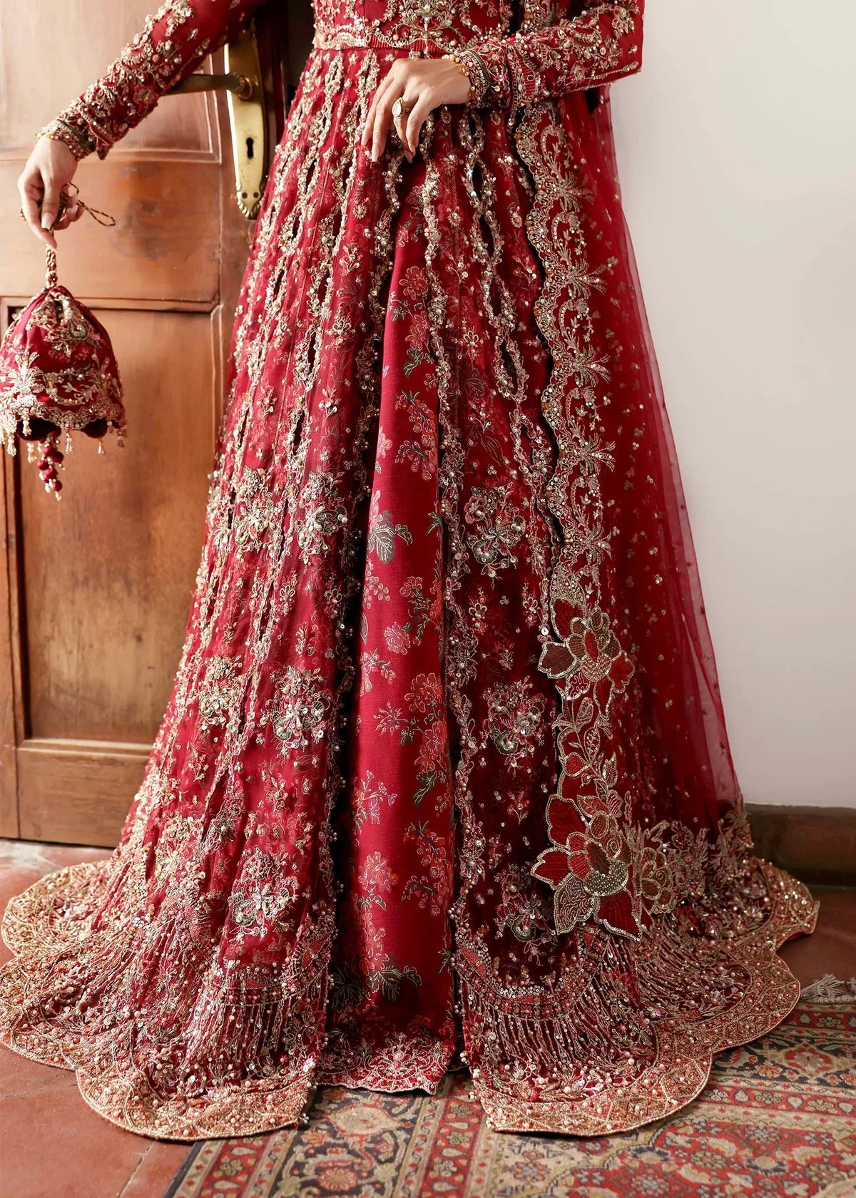 Model wearing Gulrukh by Kanwal Malik in deep red bridal ensemble with heavy embroidery – Pakistani luxury pret available online in UK.