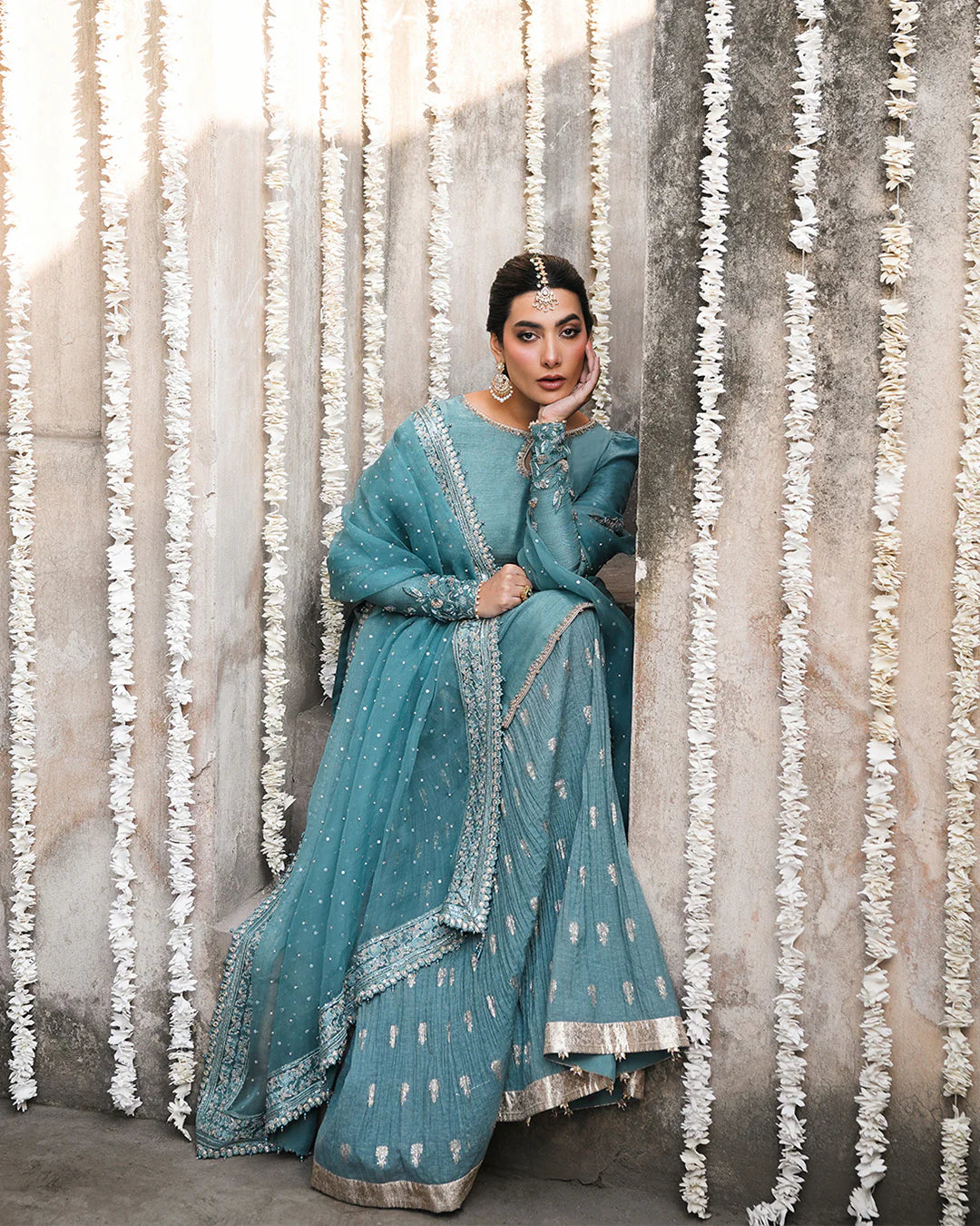 Model wearing teal blue Faiza Saqlain Tisha outfit with embellished dupatta and gharara, perfect for Pakistani luxury pret in UK.