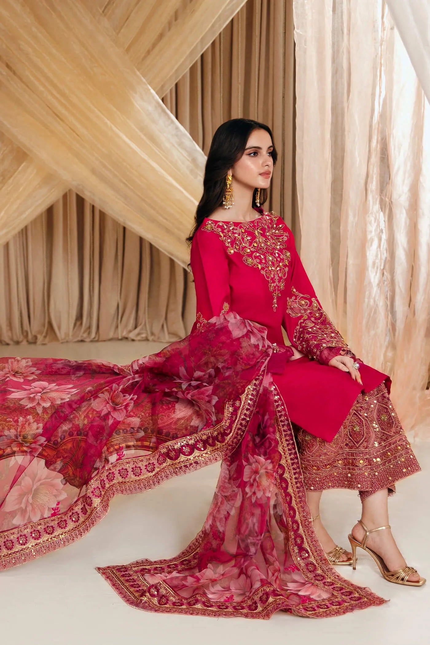 Model wearing Faiza Saqlain's Radiant Bloom dress from the Musferah Saad Mystere Eid Collection '24. A striking magenta Pakistani Eid dress with detailed gold embroidery and a floral dupatta, perfect for those seeking Pakistani designer clothes in the UK.