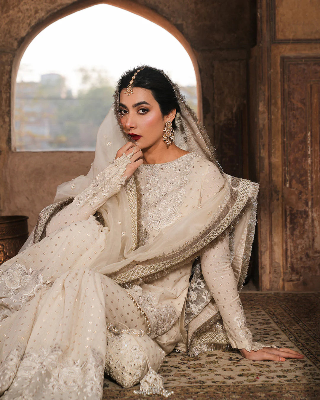 Model wearing ivory Faiza Saqlain Devina outfit with embellished gharara and dupatta, ideal for Pakistani luxury pret and festive wear in UK.