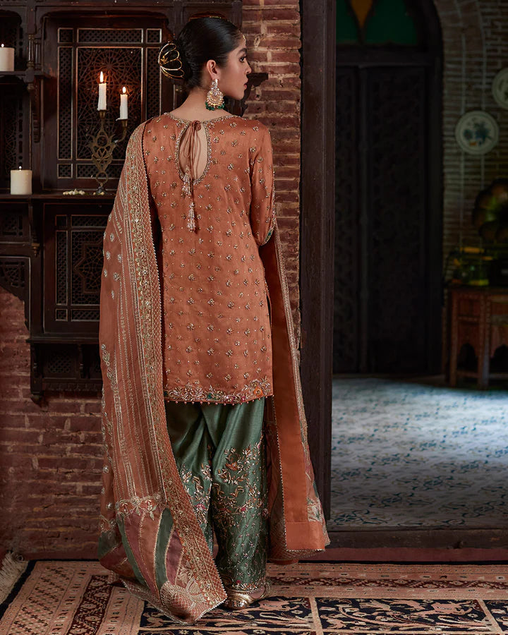 model wearing rust and green embroidered dress by Faiza Saqlain, Pakistani luxury pret available online in UK