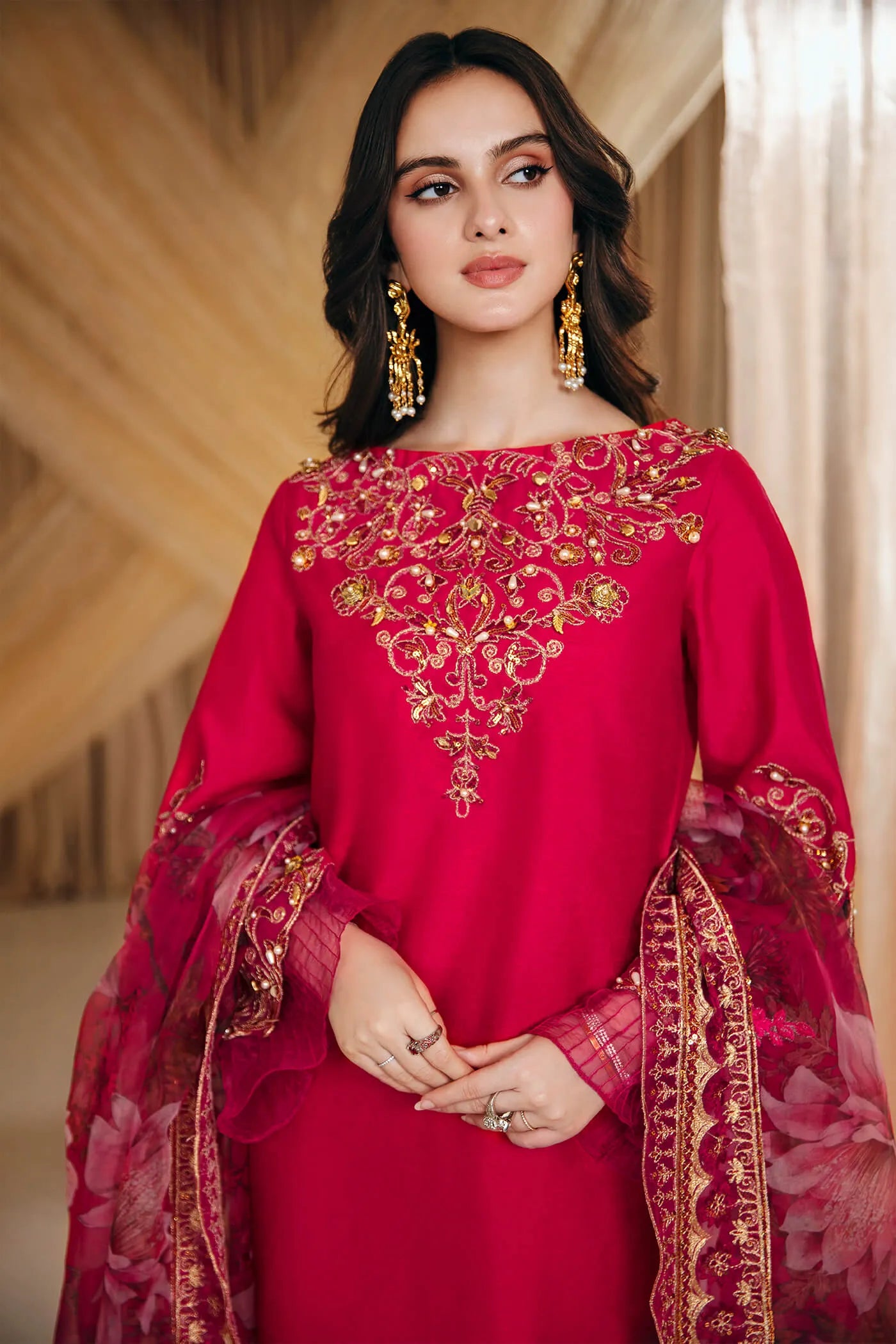 Model wearing Faiza Saqlain's Radiant Bloom dress from the Musferah Saad Mystere Eid Collection '24. A striking magenta Pakistani Eid dress with detailed gold embroidery and a floral dupatta, perfect for those seeking Pakistani designer clothes in the UK.