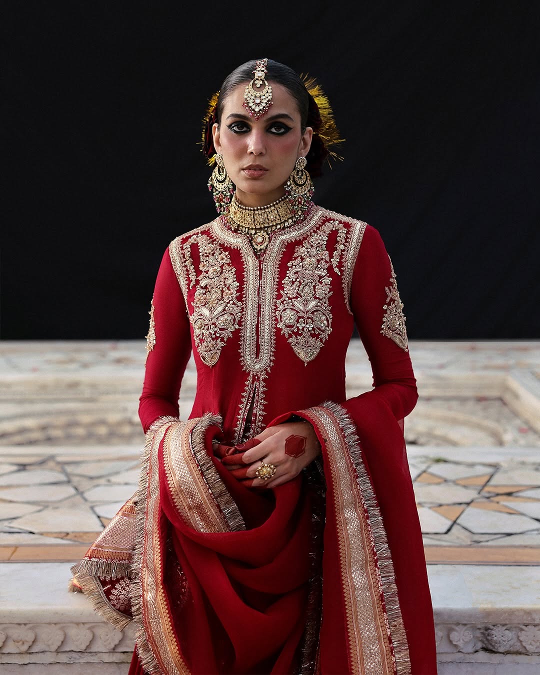 Model wearing Dilrubah by Hussain Rehar in deep red with gold embroidery – regal Pakistani luxury pret outfit in UK.
