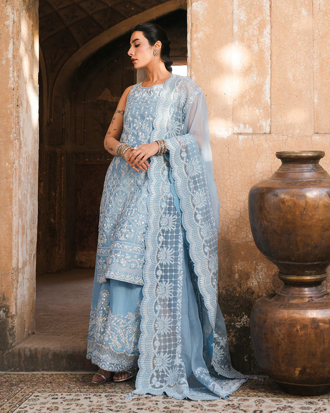 Model wearing powder blue Faiza Saqlain Yulia outfit with intricate embroidery and scalloped dupatta, ideal for Pakistani luxury pret in UK.