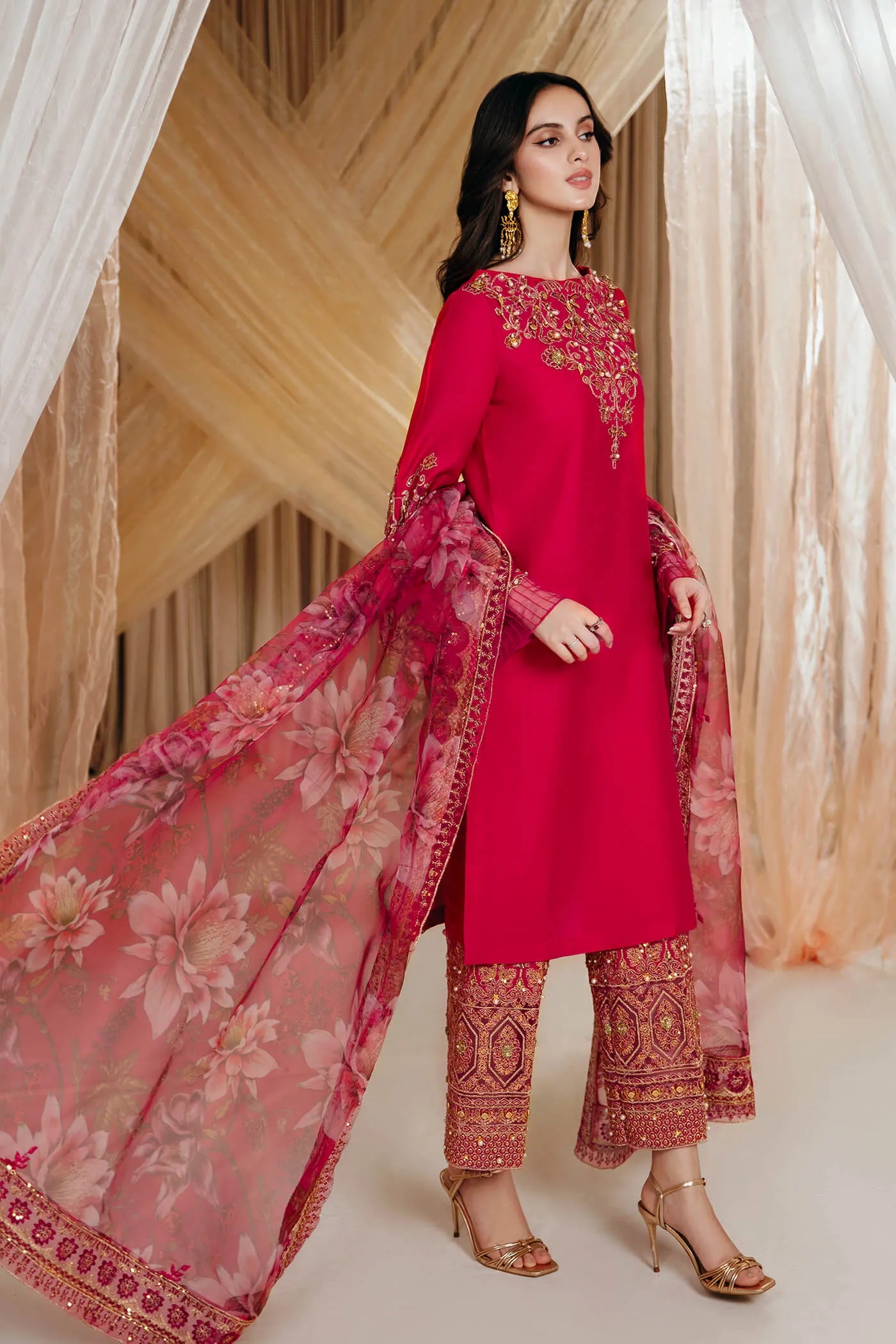 Model wearing Faiza Saqlain's Radiant Bloom dress from the Musferah Saad Mystere Eid Collection '24. A striking magenta Pakistani Eid dress with detailed gold embroidery and a floral dupatta, perfect for those seeking Pakistani designer clothes in the UK.