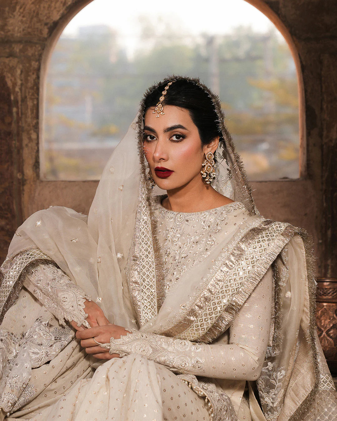 Model wearing ivory Faiza Saqlain Devina outfit with embellished gharara and dupatta, ideal for Pakistani luxury pret and festive wear in UK.