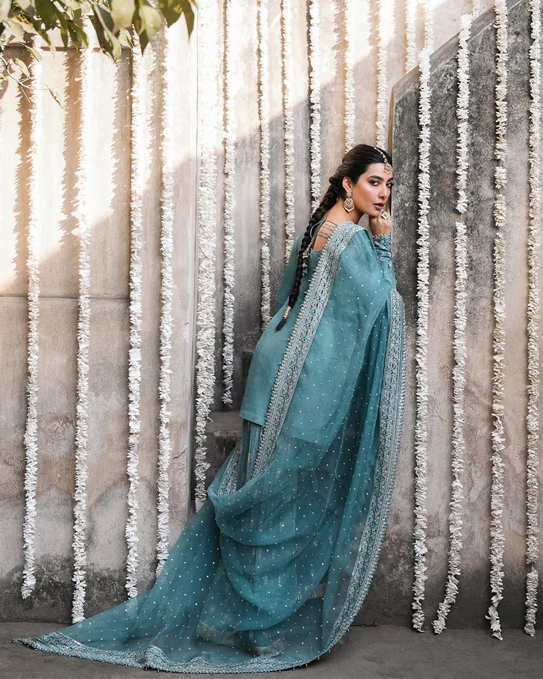 Model wearing teal blue Faiza Saqlain Tisha outfit with embellished dupatta and gharara, perfect for Pakistani luxury pret in UK.