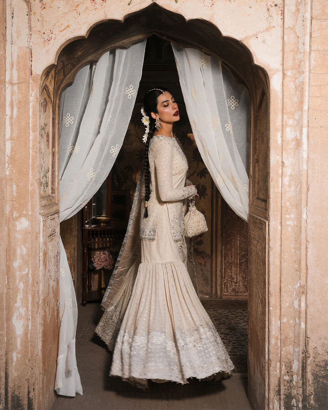 Model wearing ivory Faiza Saqlain Devina outfit with embellished gharara and dupatta, ideal for Pakistani luxury pret and festive wear in UK.