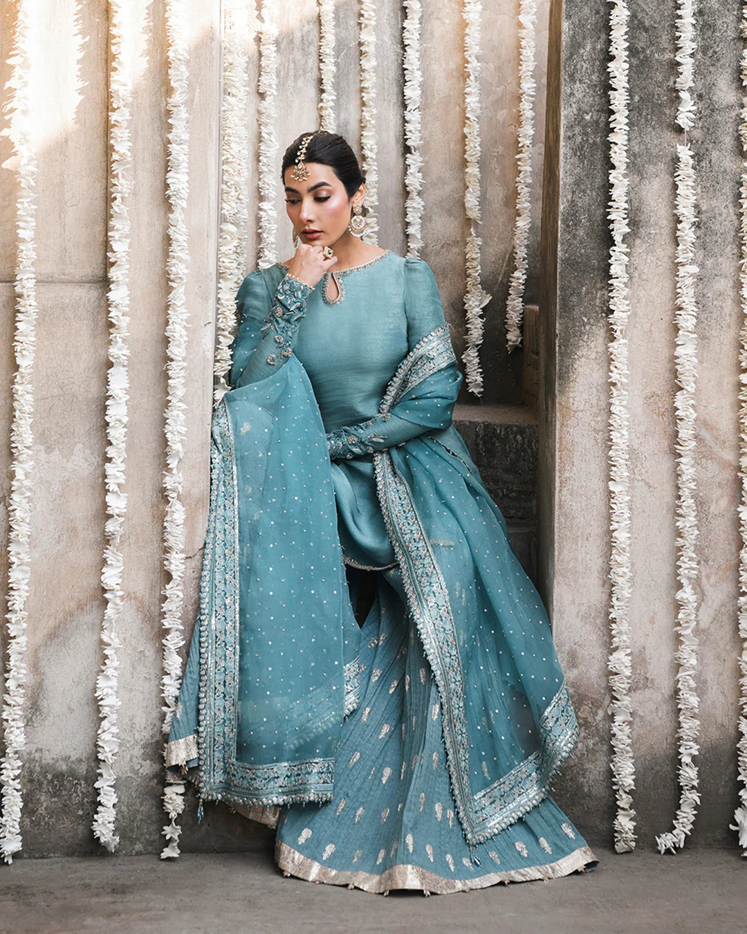 Model wearing teal blue Faiza Saqlain Tisha outfit with embellished dupatta and gharara, perfect for Pakistani luxury pret in UK.