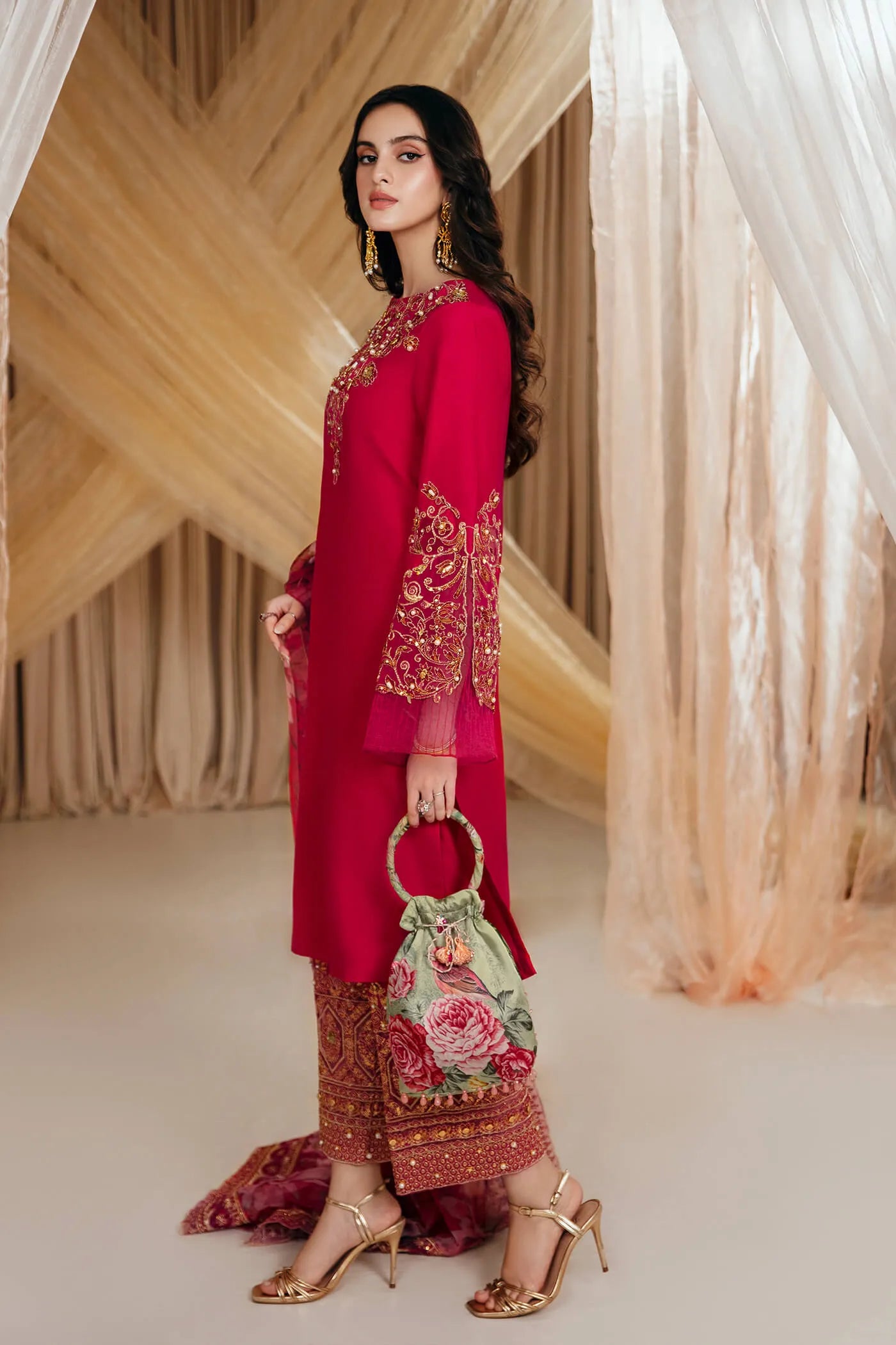 Model wearing Faiza Saqlain's Radiant Bloom dress from the Musferah Saad Mystere Eid Collection '24. A striking magenta Pakistani Eid dress with detailed gold embroidery and a floral dupatta, perfect for those seeking Pakistani designer clothes in the UK.