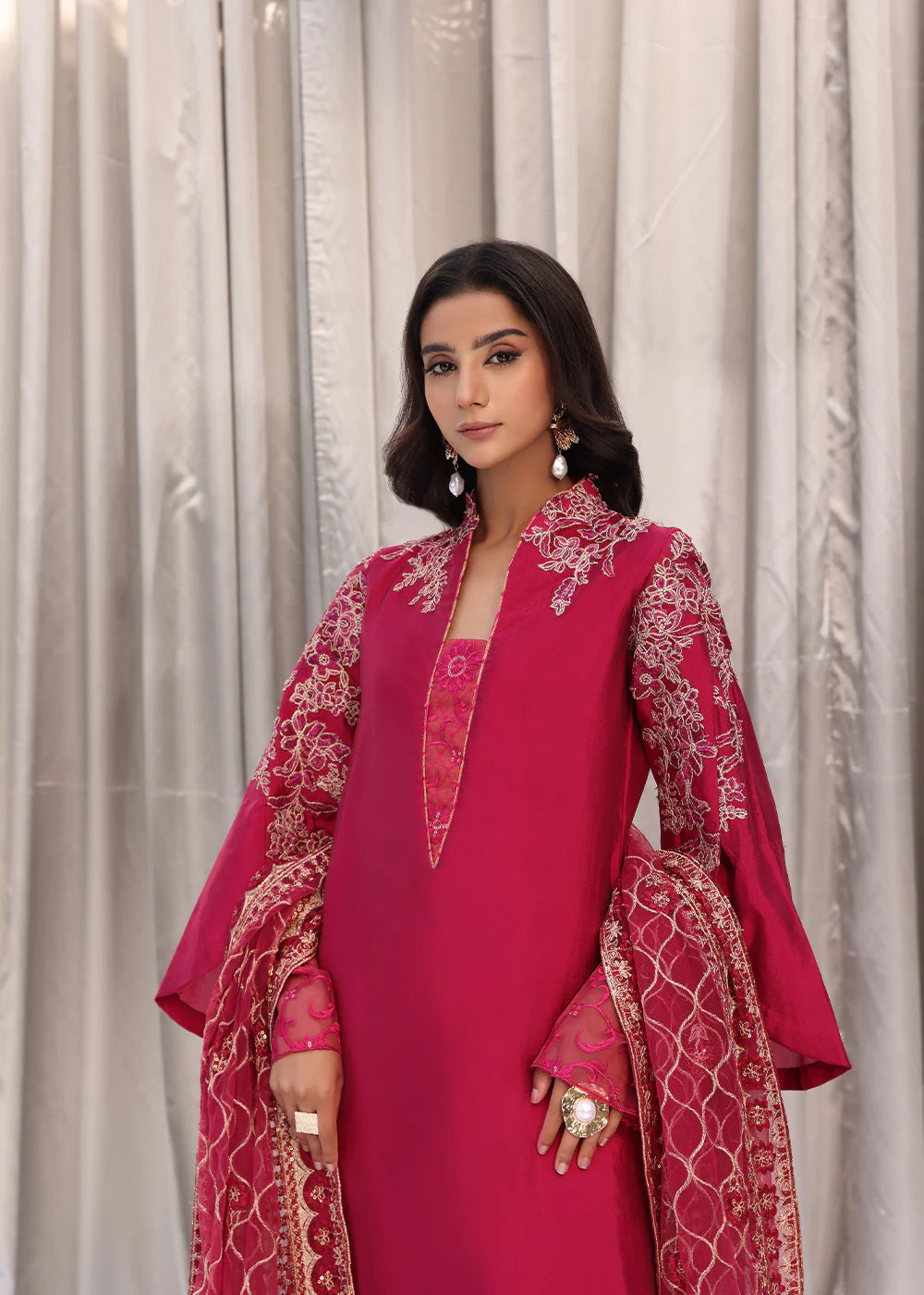 Model wearing cherry red embroidered dress with net dupatta from Musferah Saad Cherry Wine, Pakistani Luxury pret available online in UK.