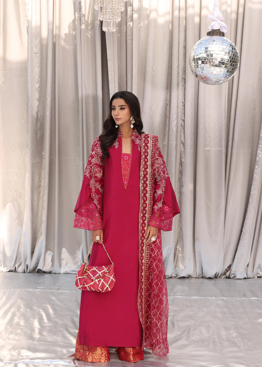 Model wearing cherry red embroidered dress with net dupatta from Musferah Saad Cherry Wine, Pakistani Luxury pret available online in UK.