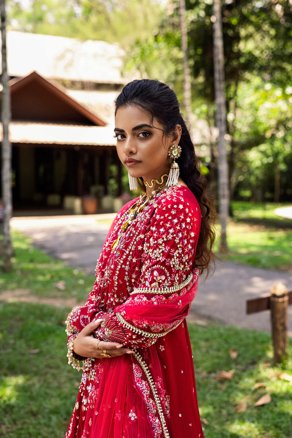 Model wearing Saira Rizwan GOLNAR-SRF25-01 in deep red with gold embellishments – Pakistani luxury pret, shop online in UK.