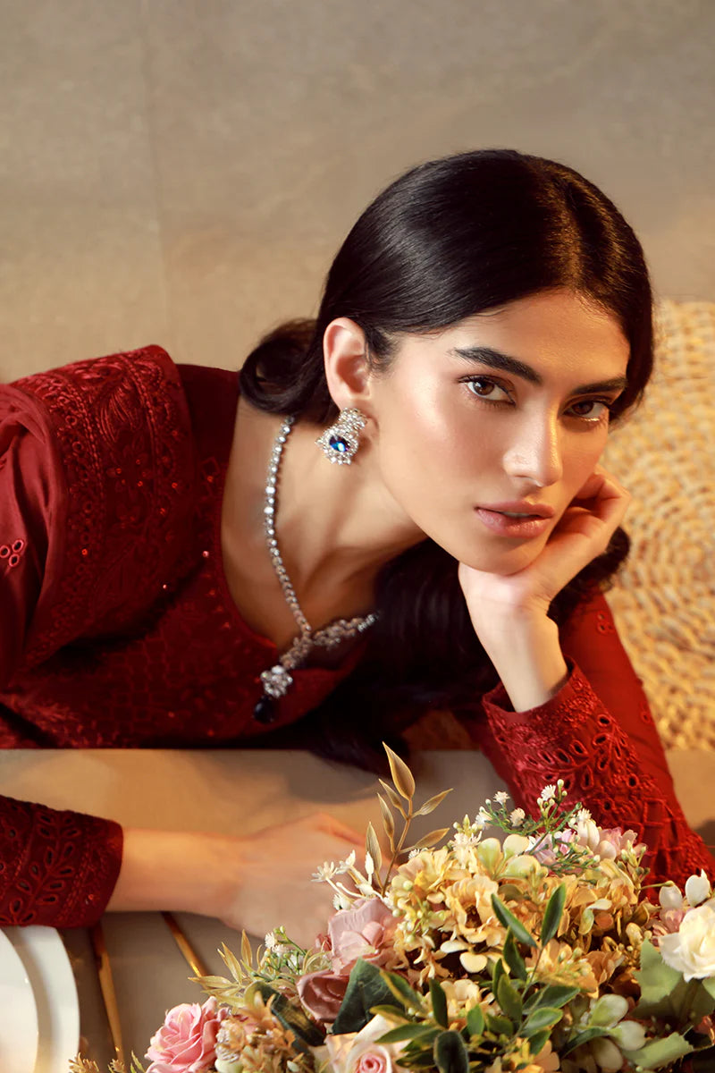 Model wearing deep red embroidered Gulaal Ella outfit, ideal for festive wear and Pakistani luxury pret available online in the UK.