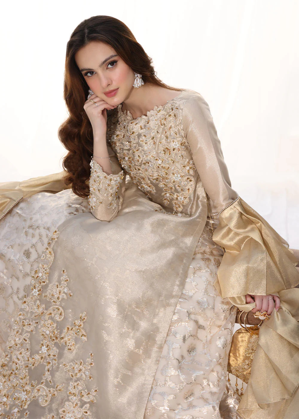 Model wearing gold embellished long dress with ruffled sleeves from Musferah Saad Golden Whispers, Pakistani Luxury pret in UK.