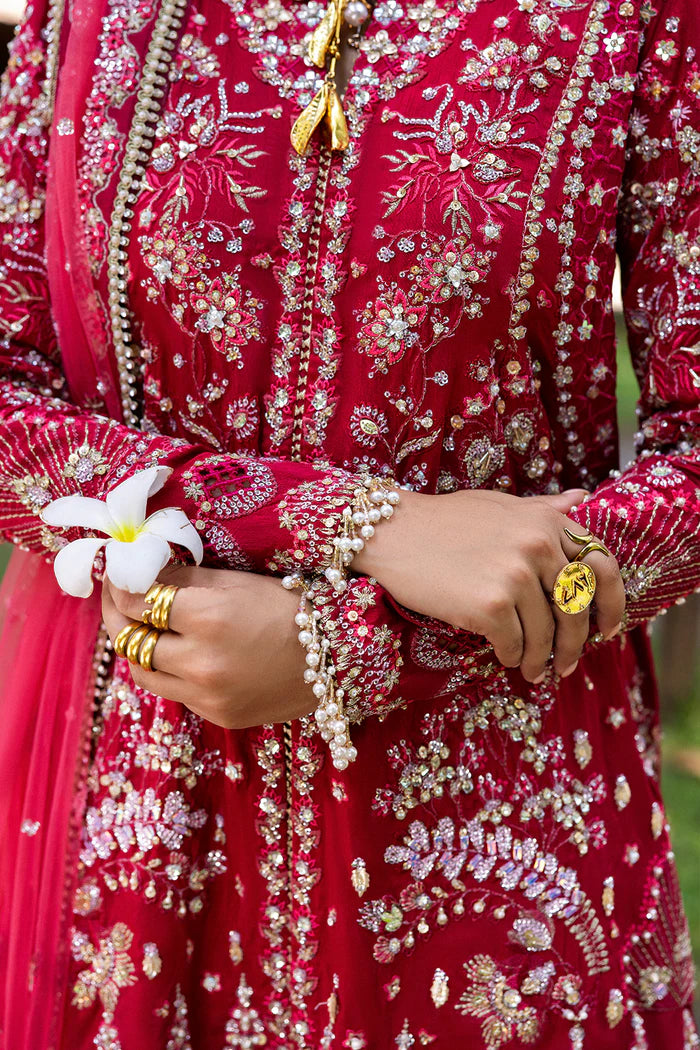 Model wearing Saira Rizwan GOLNAR-SRF25-01 in deep red with gold embellishments – Pakistani luxury pret, shop online in UK.
