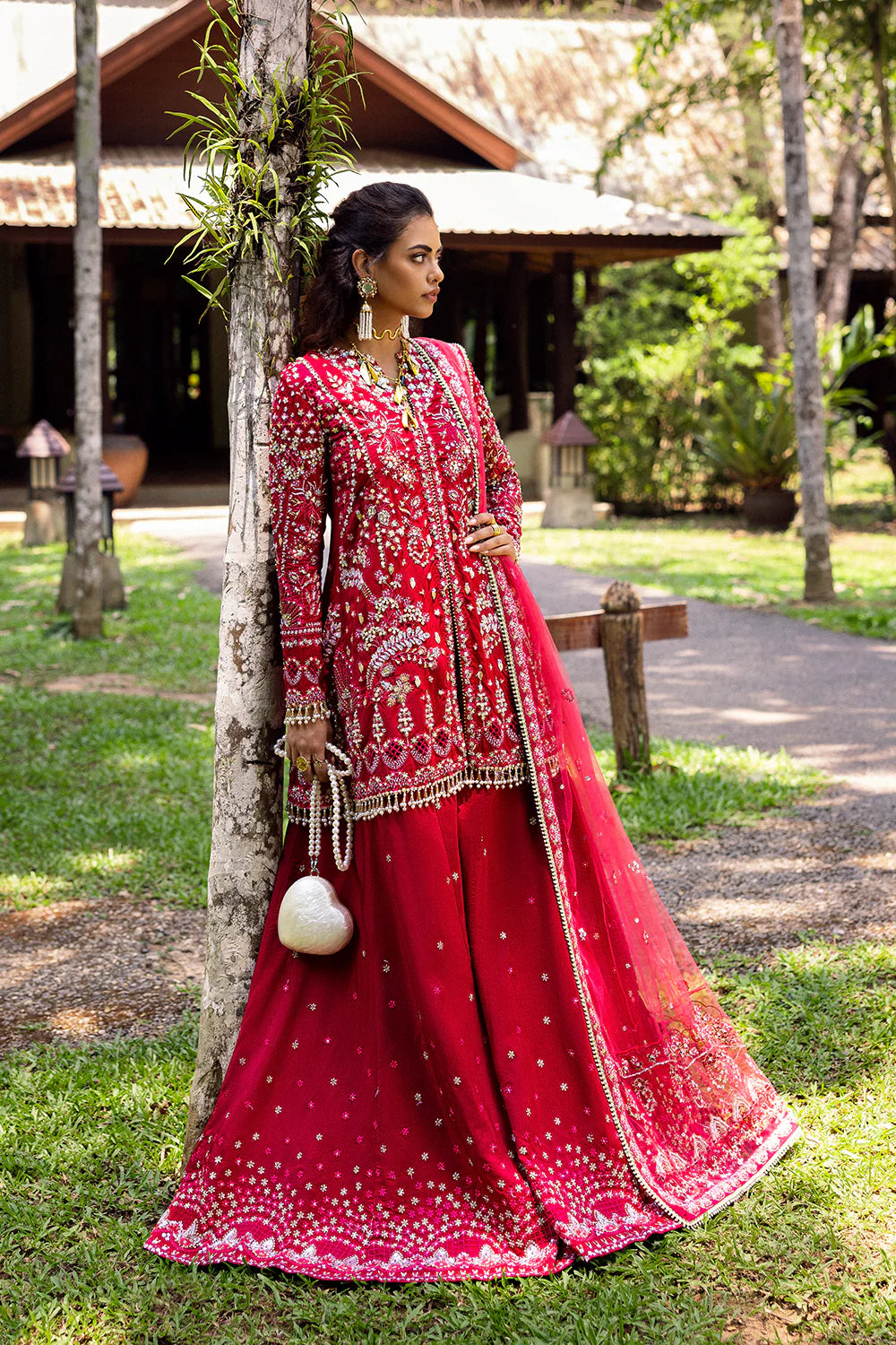Model wearing Saira Rizwan GOLNAR-SRF25-01 in deep red with gold embellishments – Pakistani luxury pret, shop online in UK.