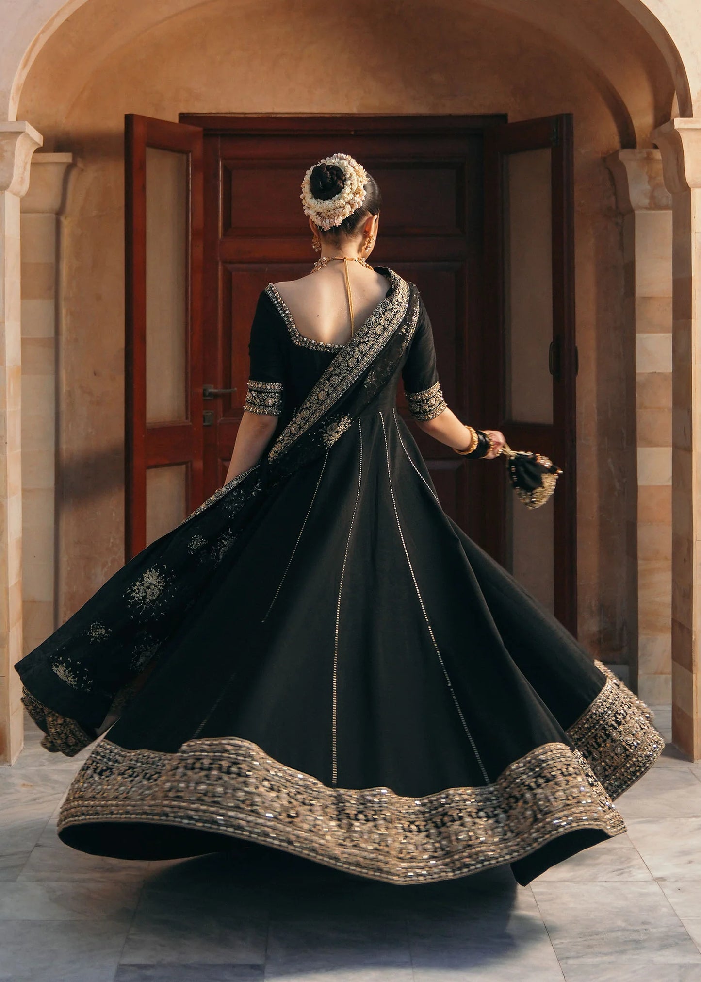 Model wearing Kajal by Kanwal Malik in black with gold embroidery and sheer dupatta – striking Pakistani luxury pret outfit in UK.