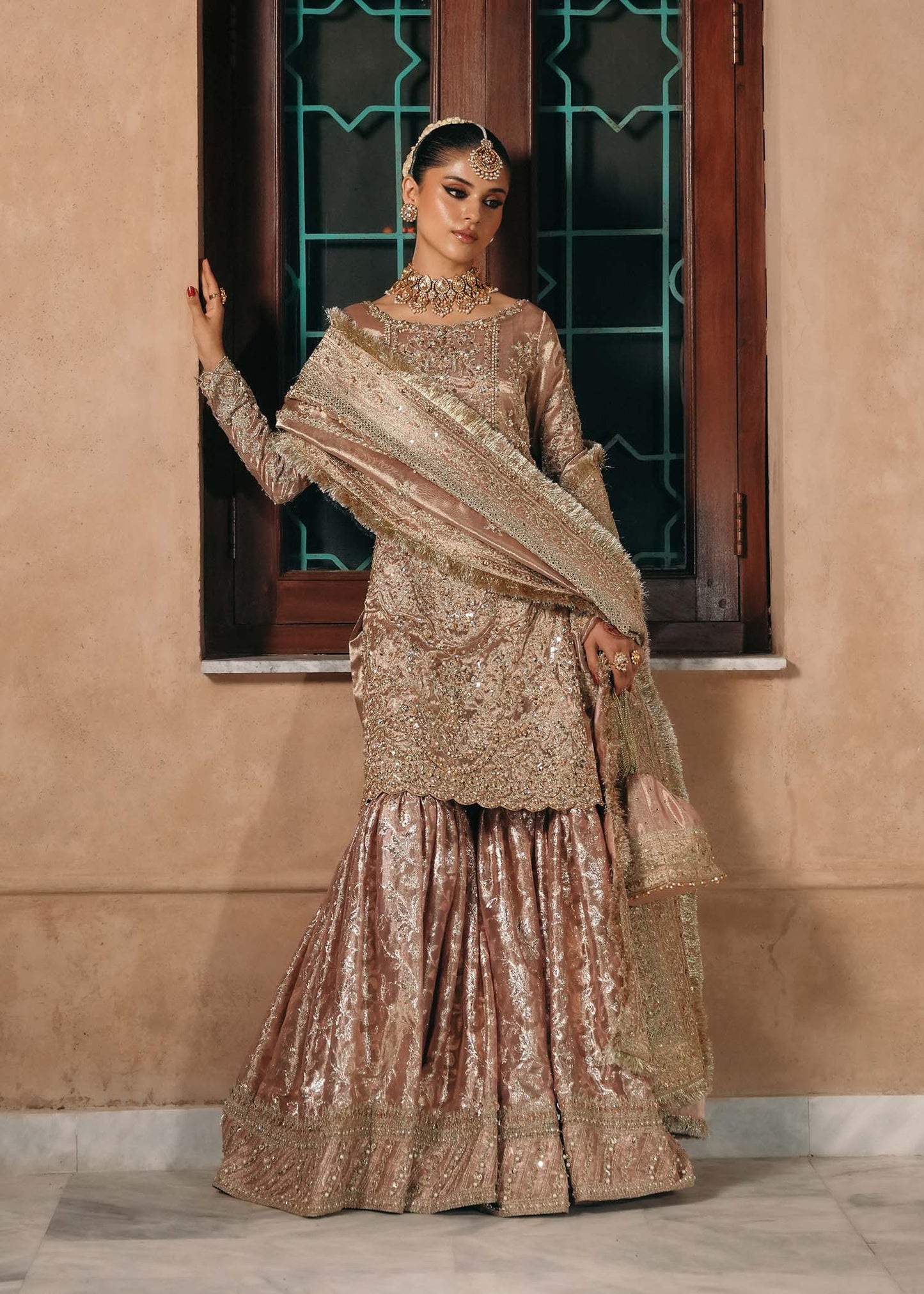 Model wearing Nazo by Kanwal Malik in dusty rose with gold embellishments – elegant Pakistani luxury pret for weddings in the UK.