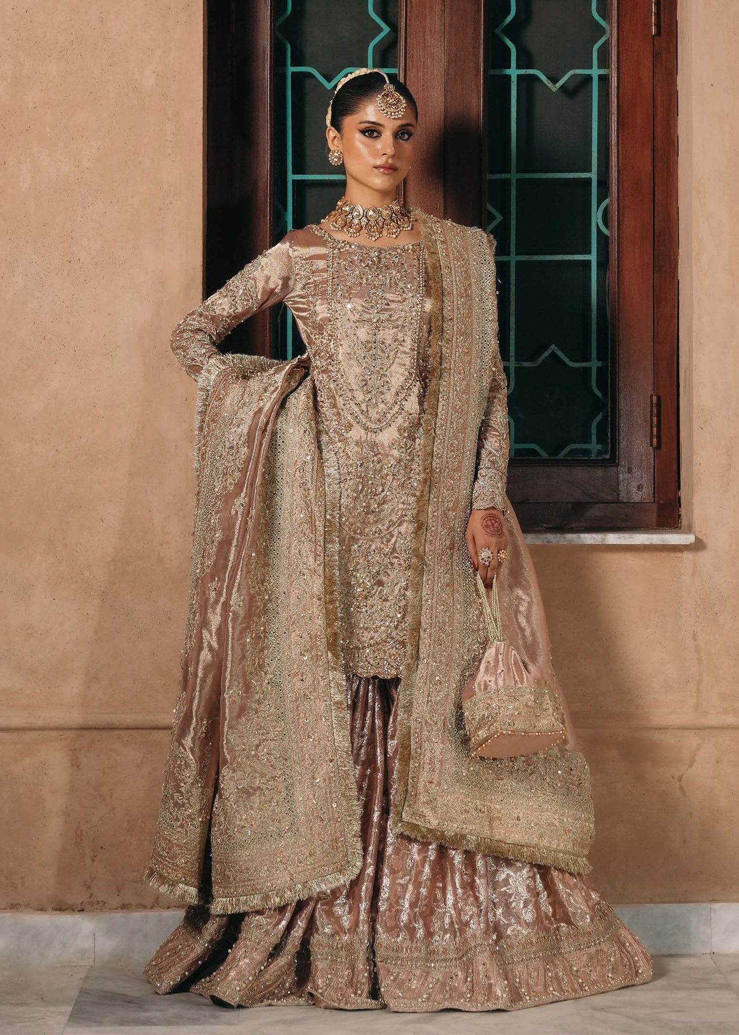 Model wearing Nazo by Kanwal Malik in dusty rose with gold embellishments – elegant Pakistani luxury pret for weddings in the UK.