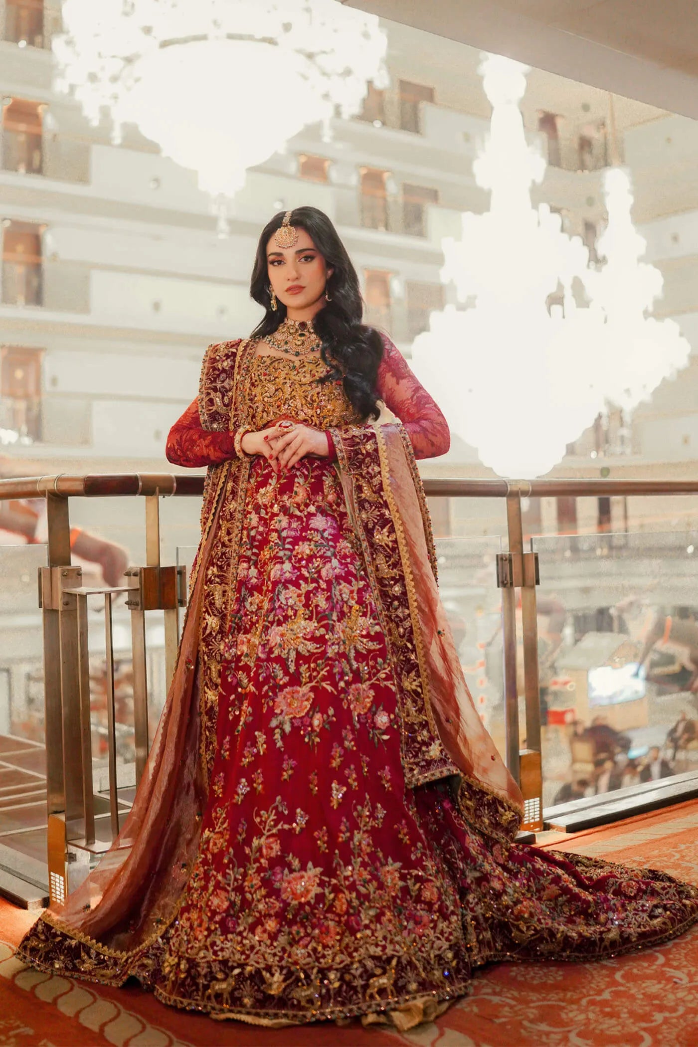 Model wearing Musferah Saad Royal Goddess, rich red Pakistani bridal attire, UK.