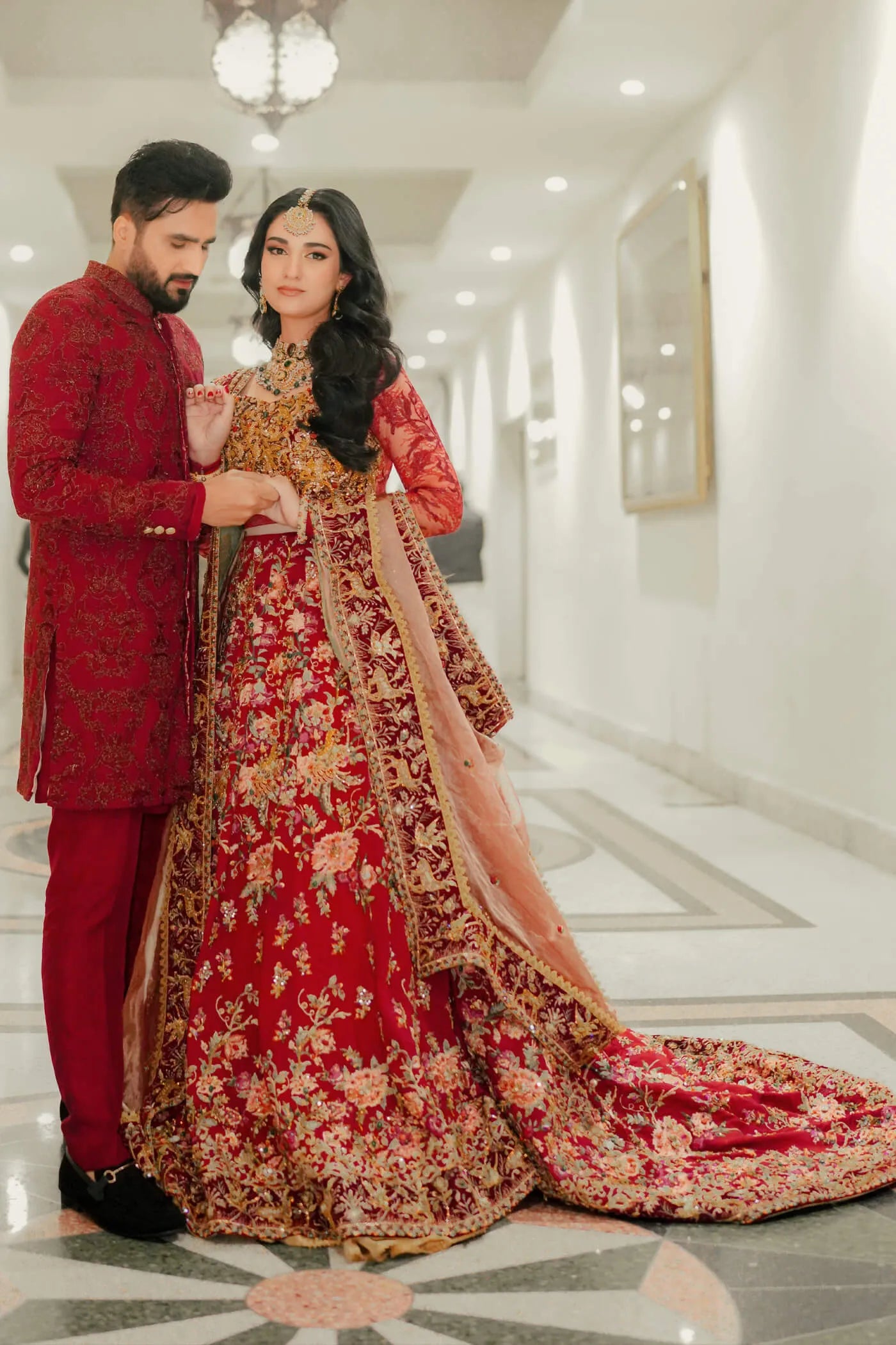 Couple in Musferah Saad Scarlet Monarch, Pakistani bridal dress and sherwani in UK.