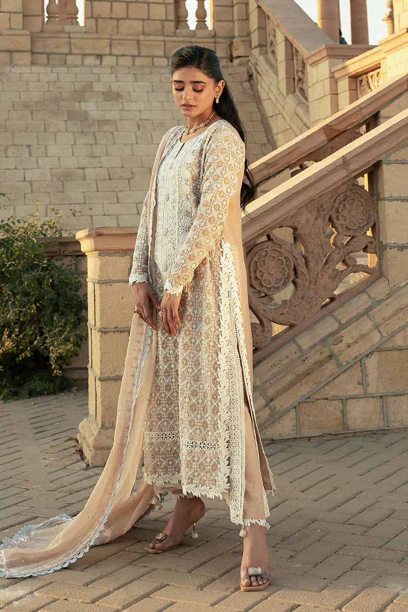 Model wearing Mushq Saugaat City of Lights Faria in beige with intricate embroidery. Shop Pakistani luxury pret online in the UK.