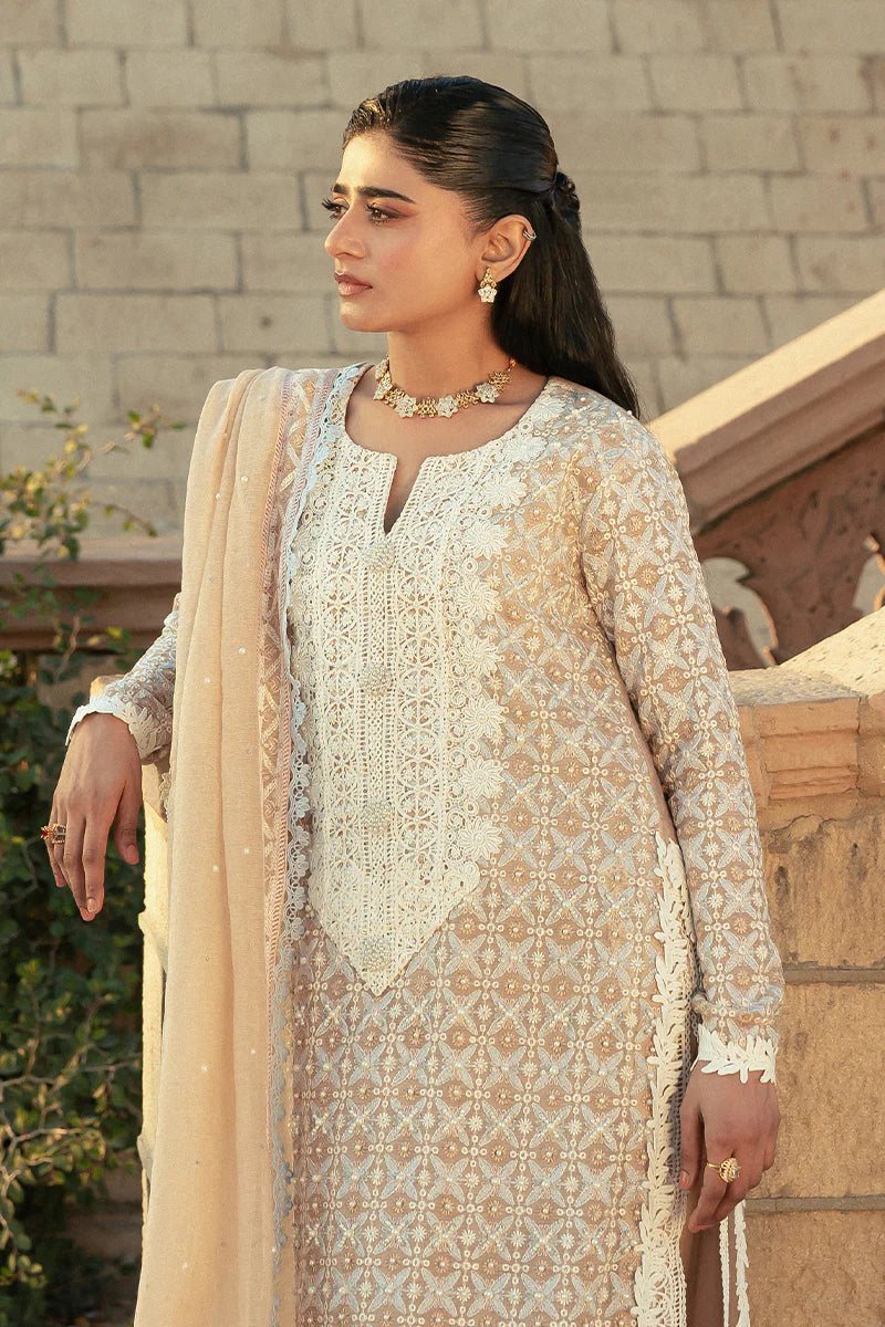 Model wearing Mushq Saugaat City of Lights Faria in beige with intricate embroidery. Shop Pakistani luxury pret online in the UK.