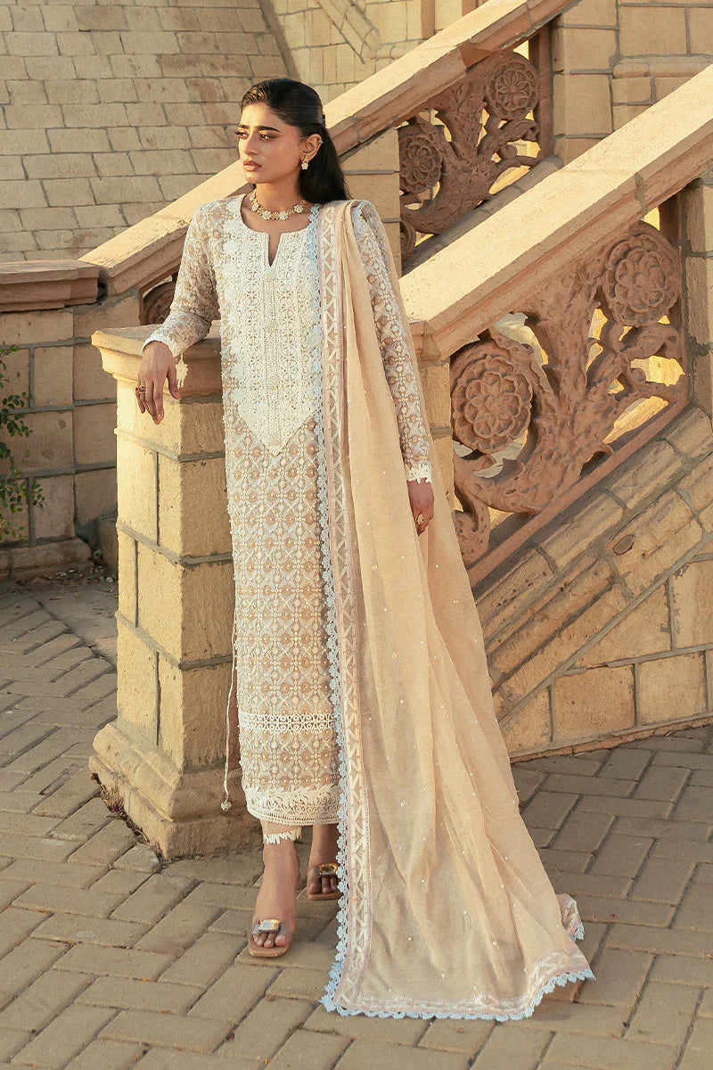 Model wearing Mushq Saugaat City of Lights Faria in beige with intricate embroidery. Shop Pakistani luxury pret online in the UK.