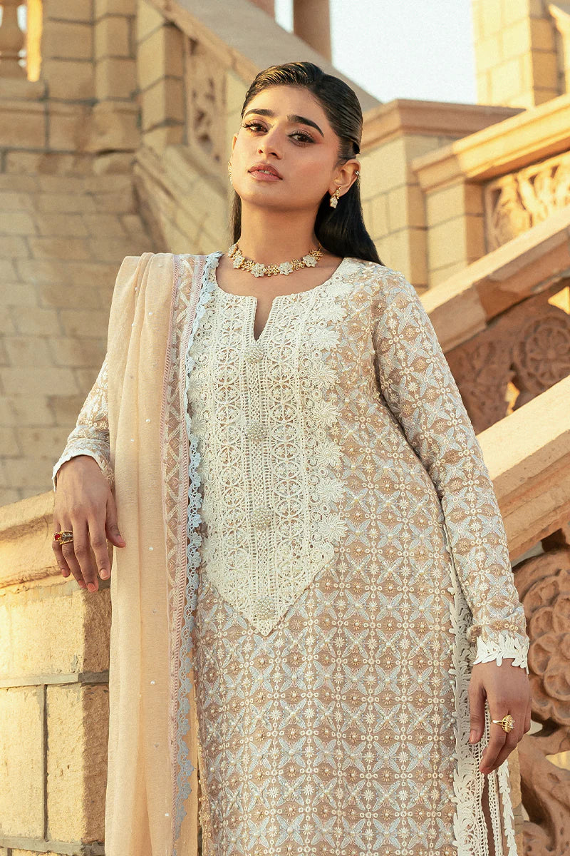 Model wearing Mushq Saugaat City of Lights Faria in beige with intricate embroidery. Shop Pakistani luxury pret online in the UK.
