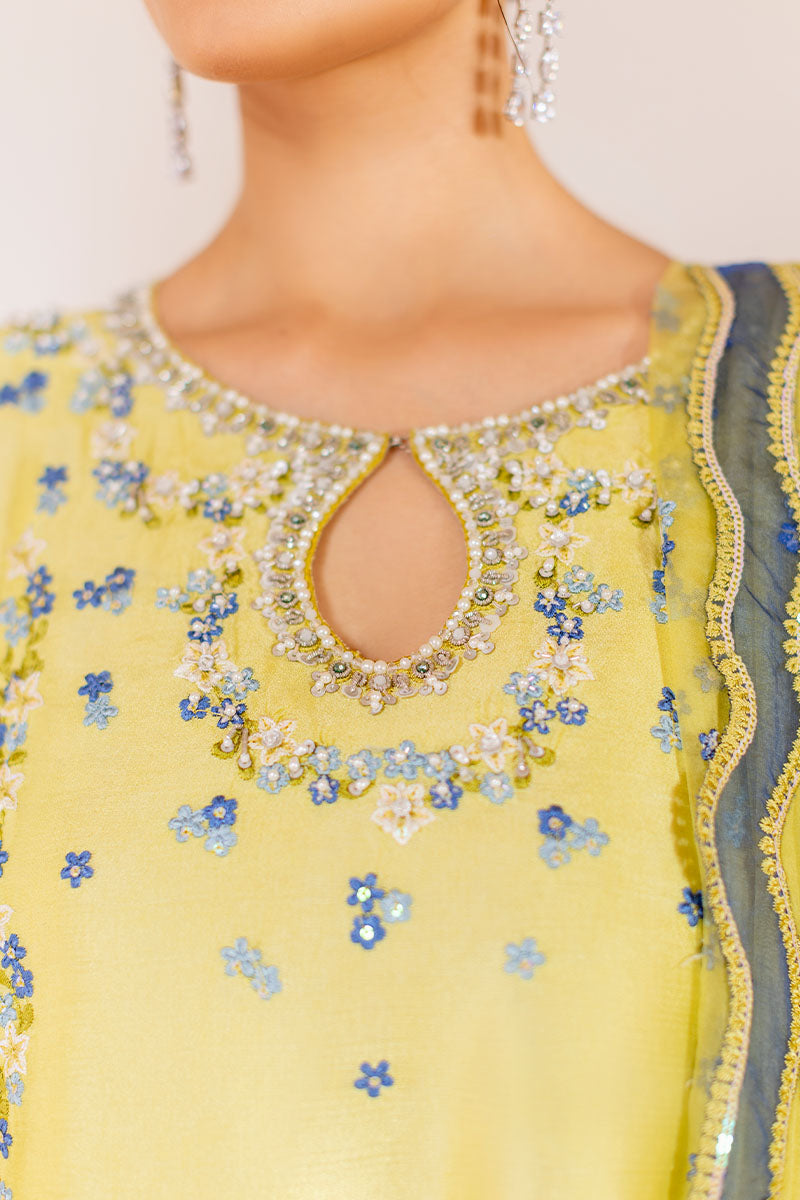 Model wearing lemon yellow Lumiere dress from Mushq with delicate blue embroidery, perfect for Pakistani luxury pret and clothes online in UK.