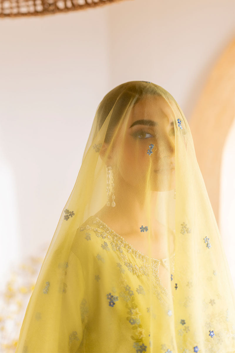 Model wearing lemon yellow Lumiere dress from Mushq with delicate blue embroidery, perfect for Pakistani luxury pret and clothes online in UK.