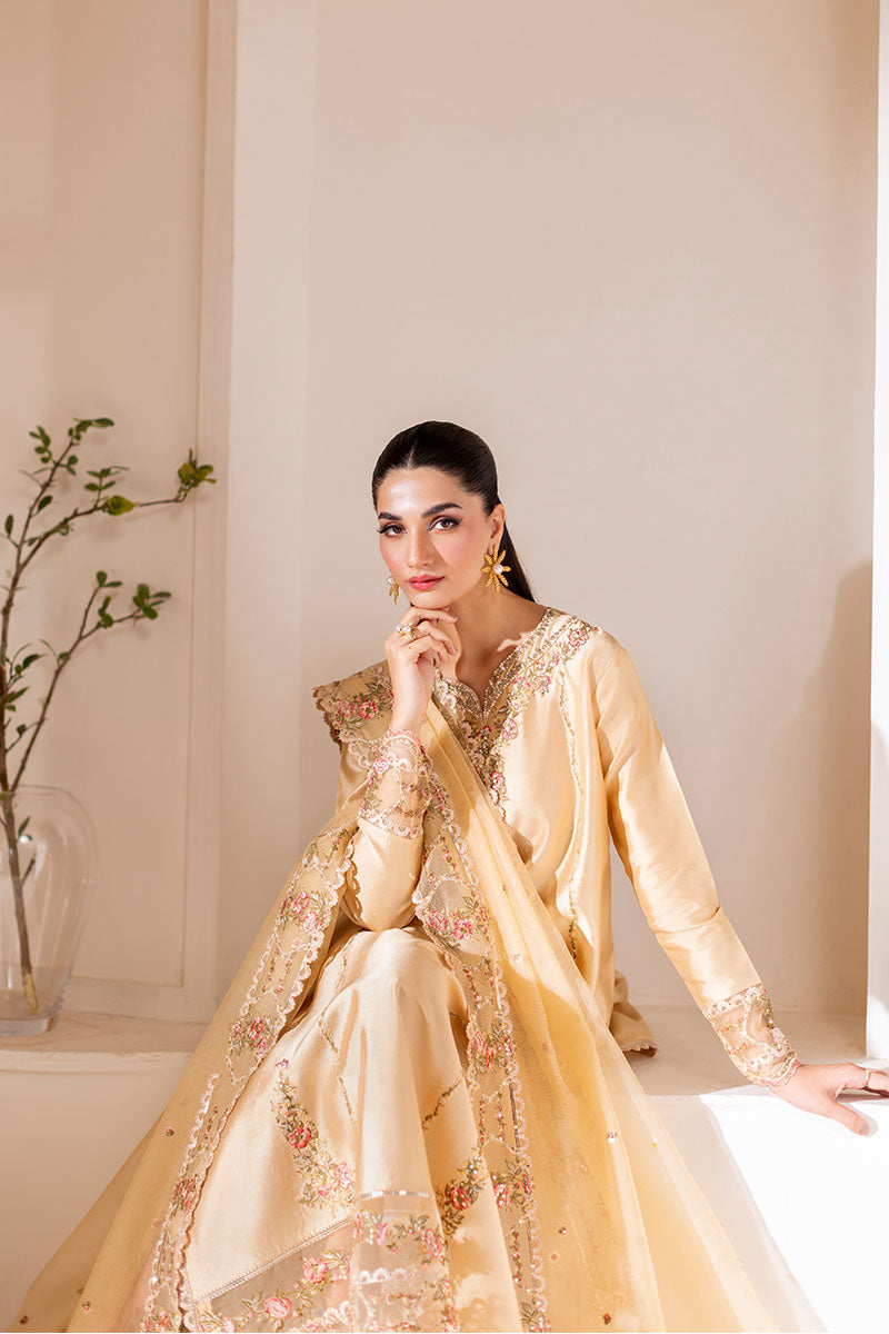 Model wearing golden Aurea dress from Mushq featuring intricate embellishments, ideal for Pakistani luxury pret and clothes online in UK.