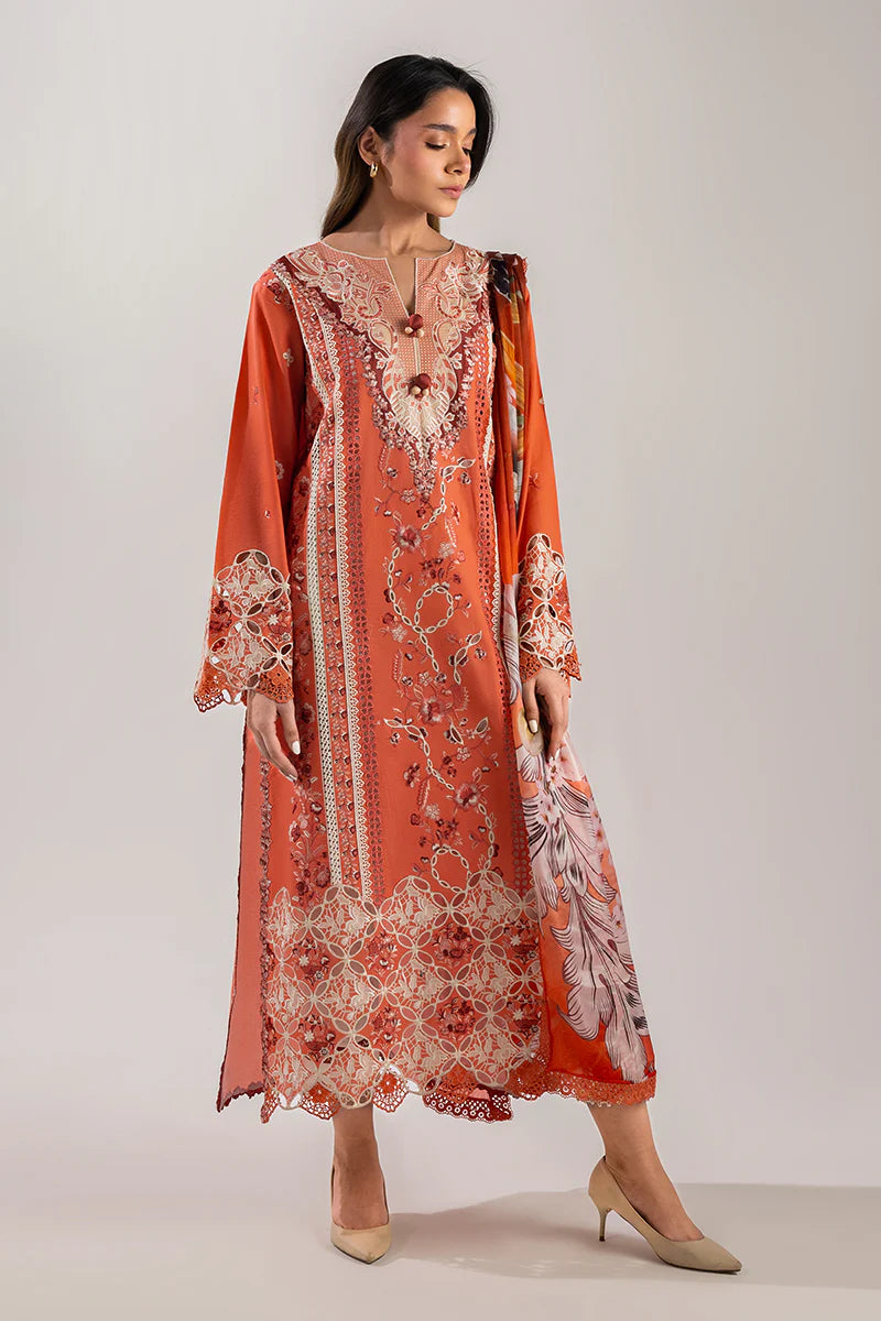 Model wearing burnt orange embroidered dress from Mushq Manaram Luxury Lawn '25 Starry Side, Pakistani luxury pret available online in UK.