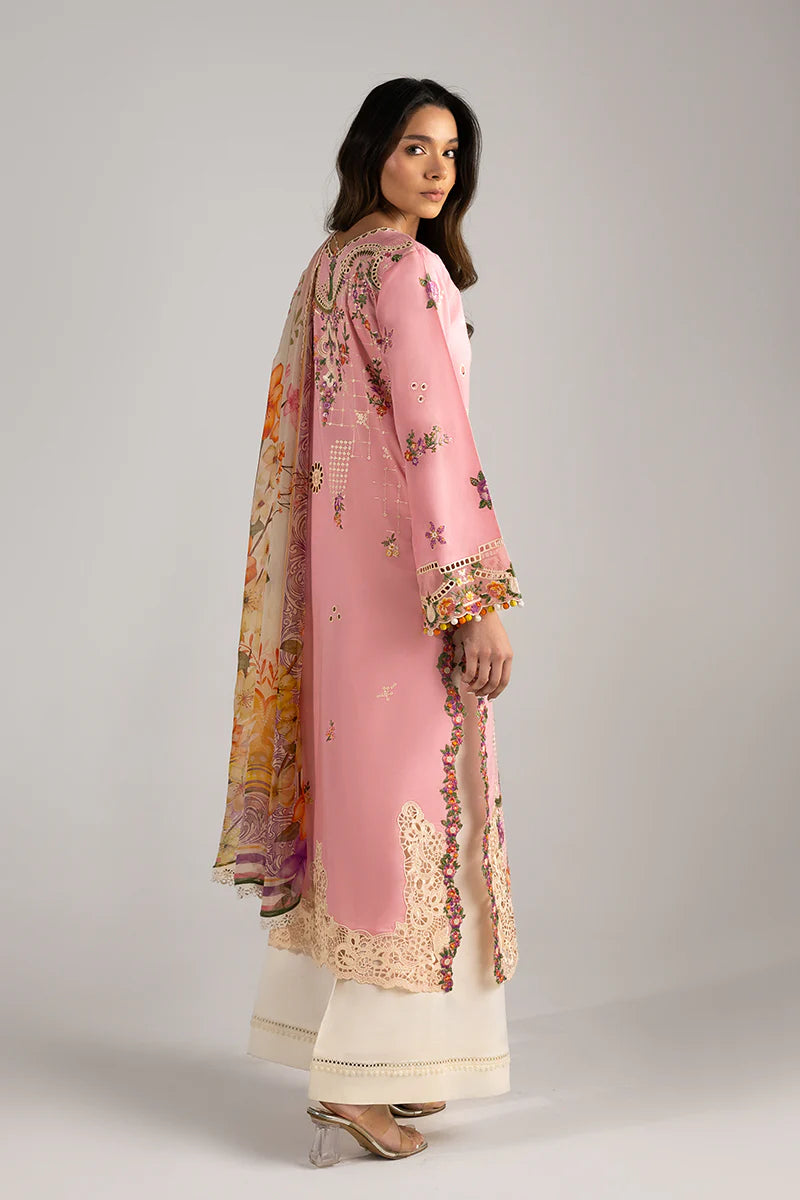 Model wearing blush pink embroidered dress with floral detailing and lace border from Mushq Manaram Luxury Lawn '25 Twinkling Tempos, Pakistani clothes online in UK.