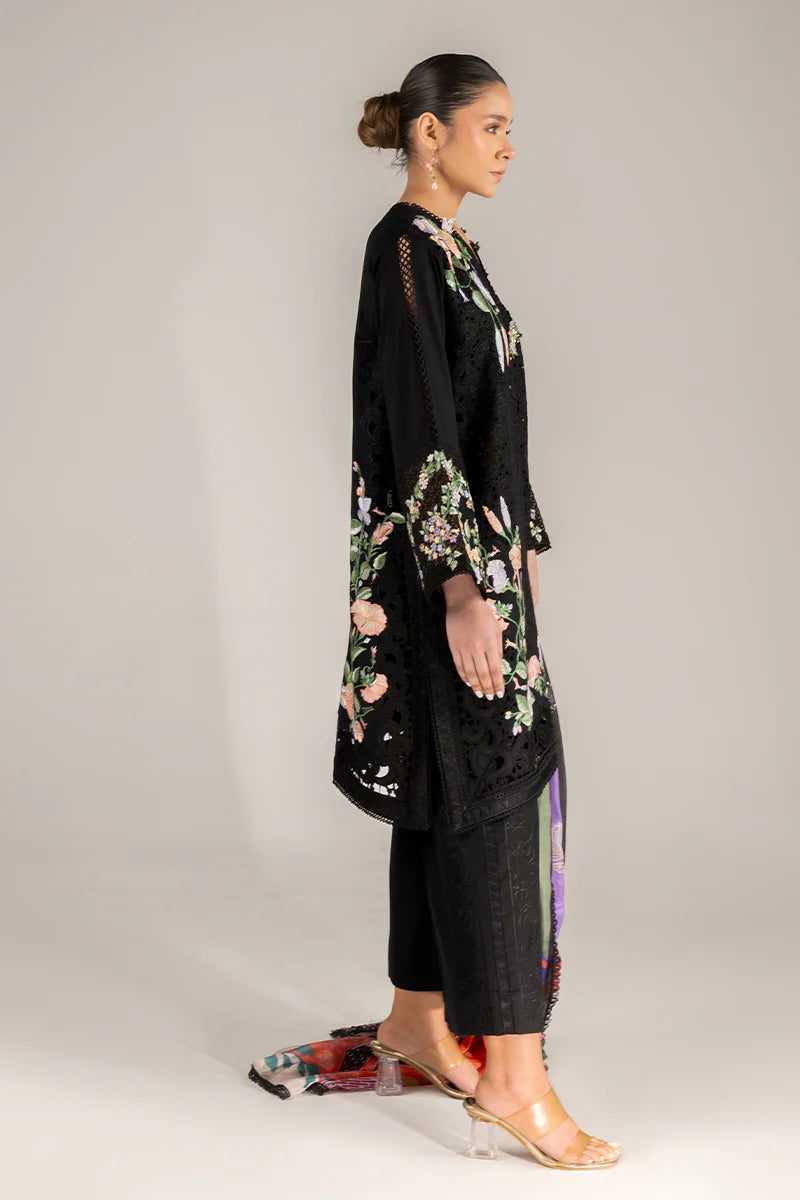 Model wearing black embroidered floral shirt with matching trousers and multicolour dupatta from Mushq Manaram Luxury Lawn 2025 Dazzling Glimmer. Pakistani clothes online UK.