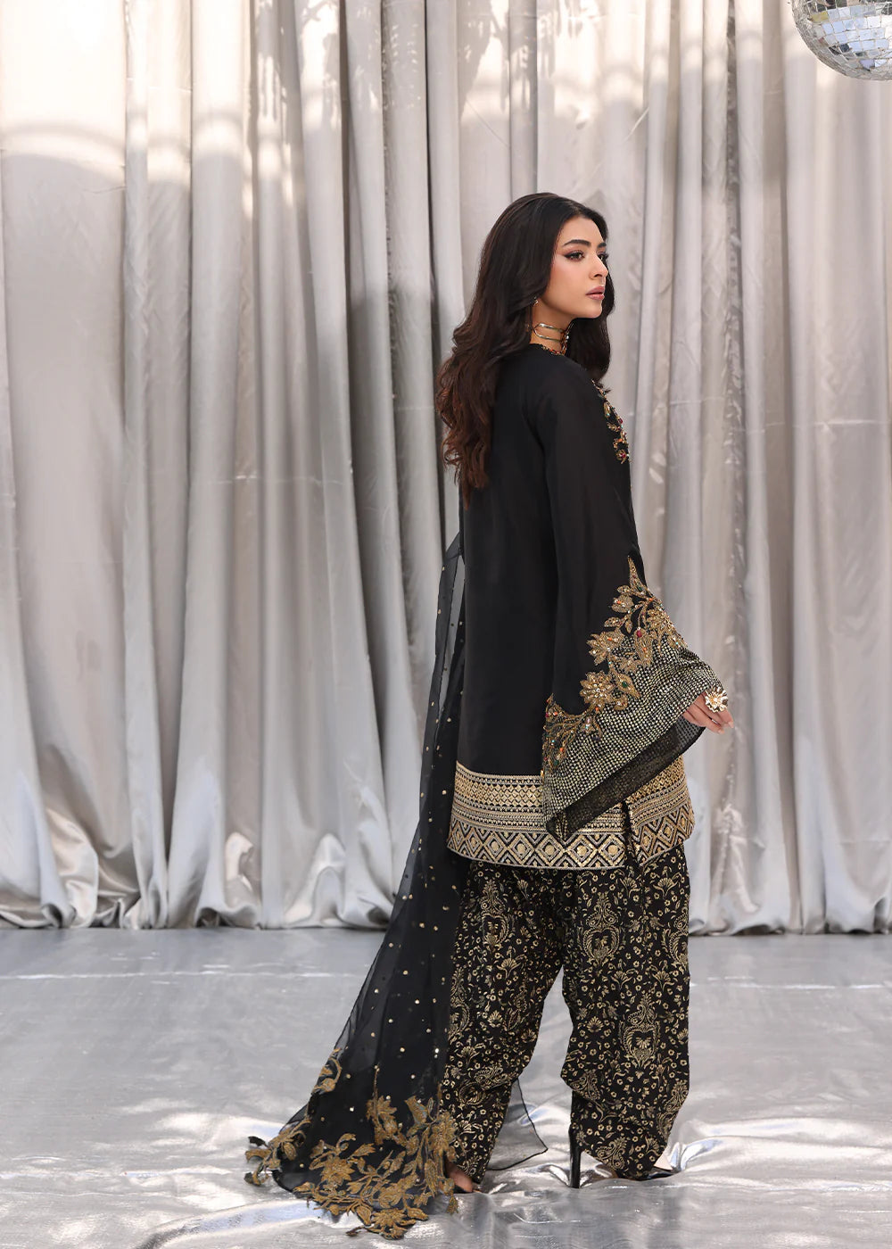Model wearing black and gold embroidered dress with matching dupatta from Musferah Saad Midnight Bloom, Pakistani Luxury pret in UK.
