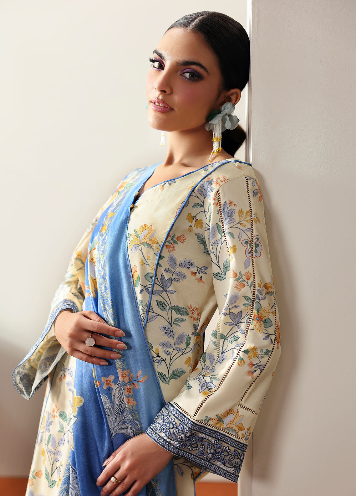 Model wearing cream and blue floral outfit from Gulaal Basics | Elaris, elegant Pakistani luxury pret available online in UK.